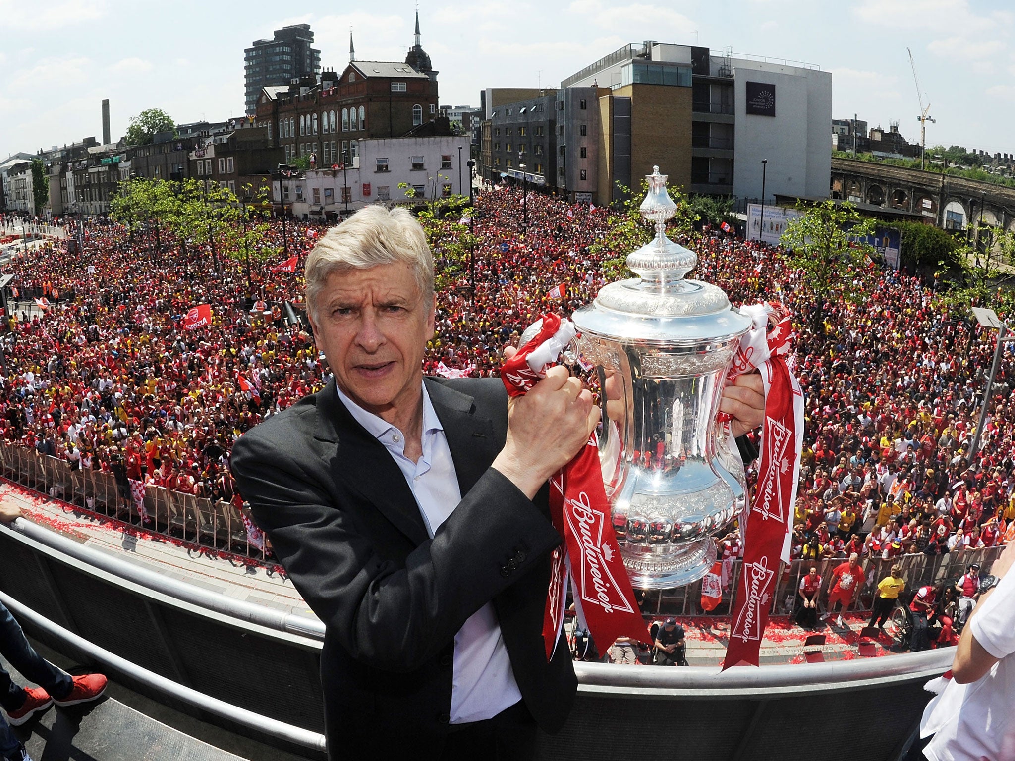 Arsenal manager Arsene Wenger poses with the trophy at the Victory Parade