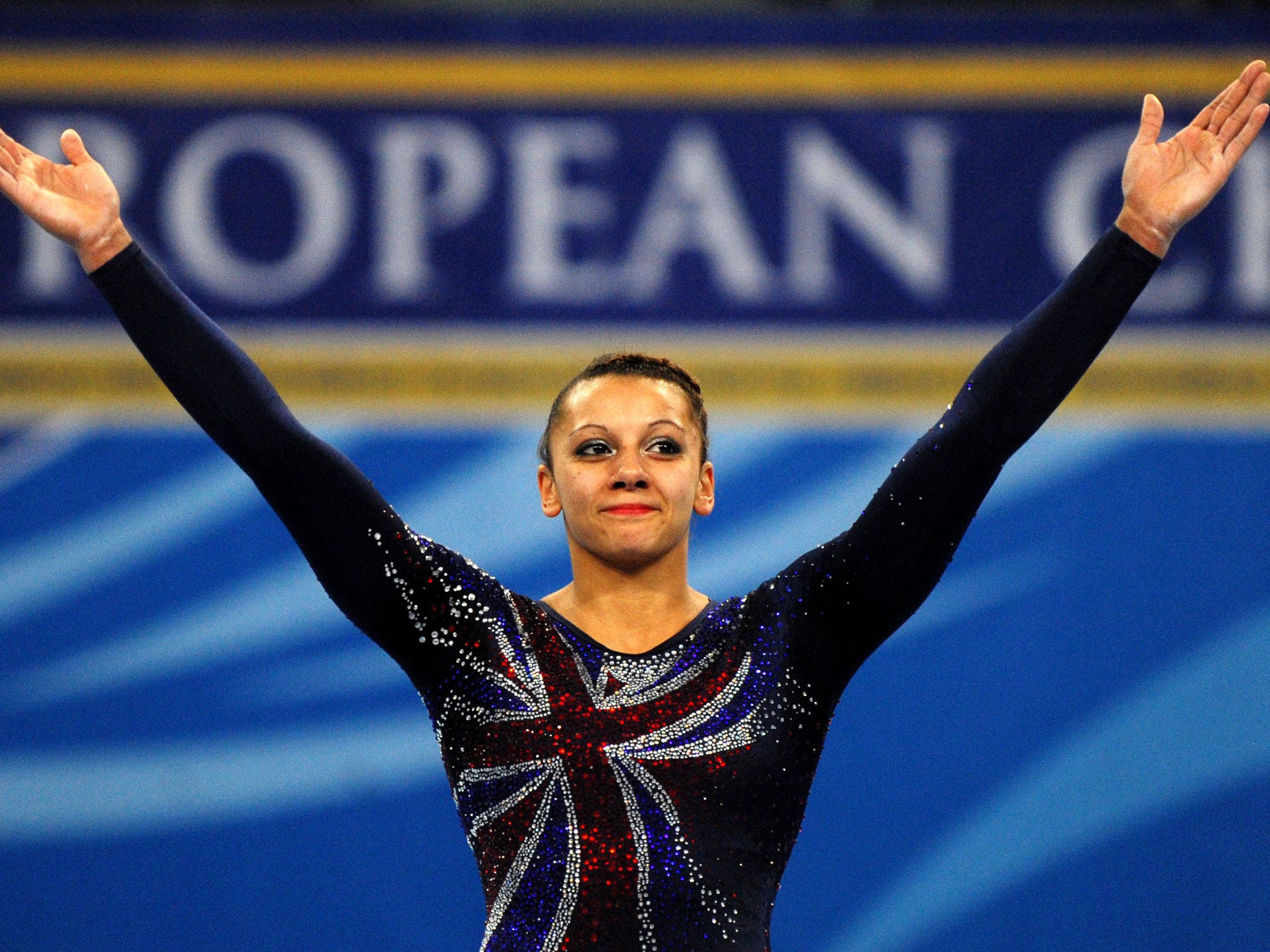 Great Britain's Rebecca Downie celebrates on the podium after wining a gold medal on Uneven Bars