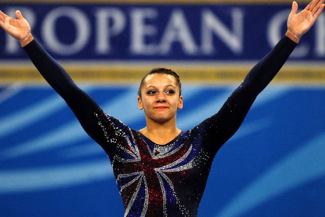 Great Britain's Rebecca Downie celebrates on the podium after wining a gold medal on Uneven Bars