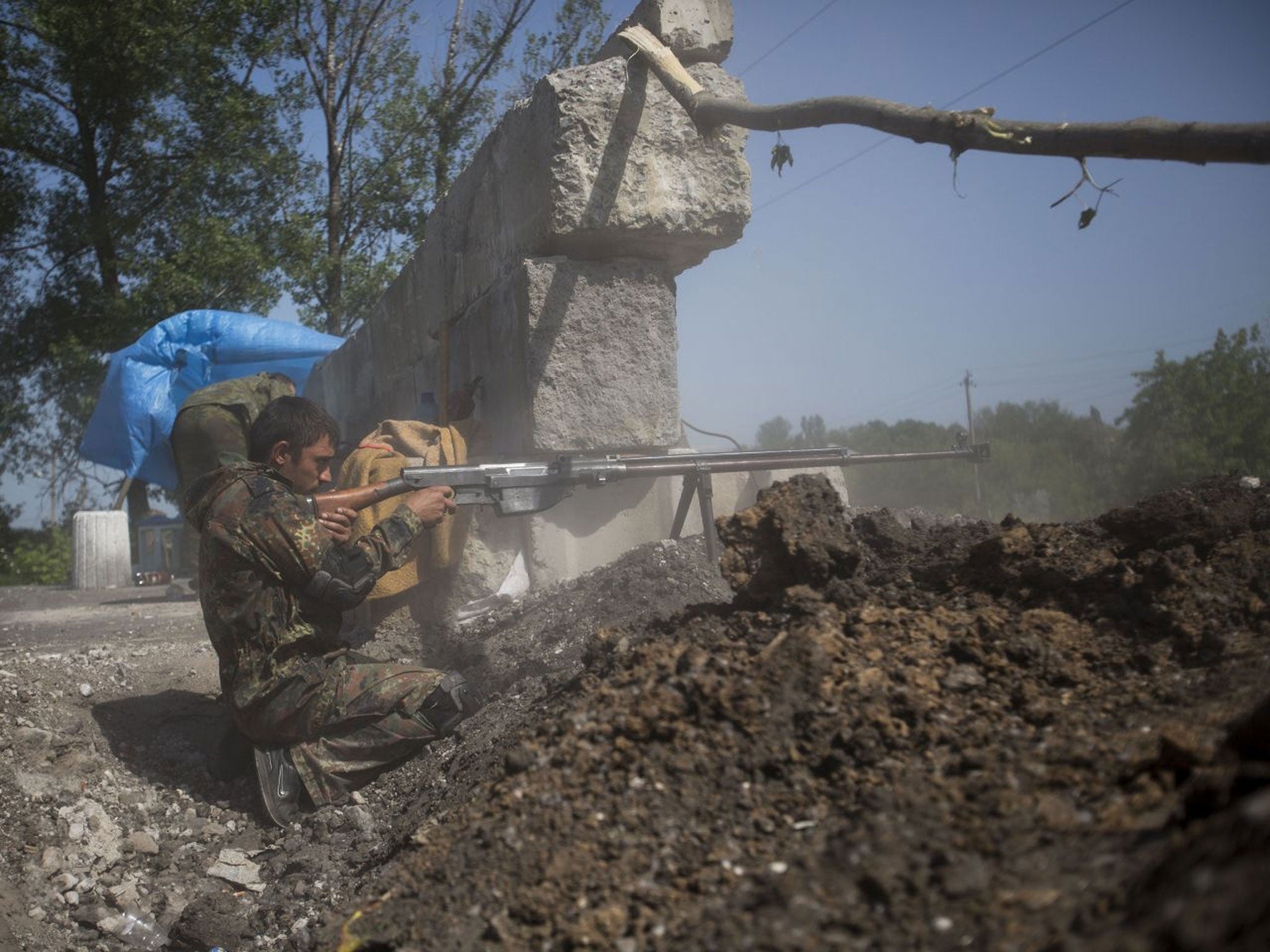 A pro-Russian militant test-fires an anti-tank weapon preparing to fight against Ukrainian government troops at a checkpoint blocking the major highway which links Kharkiv, outside Slovyansk, eastern Ukraine