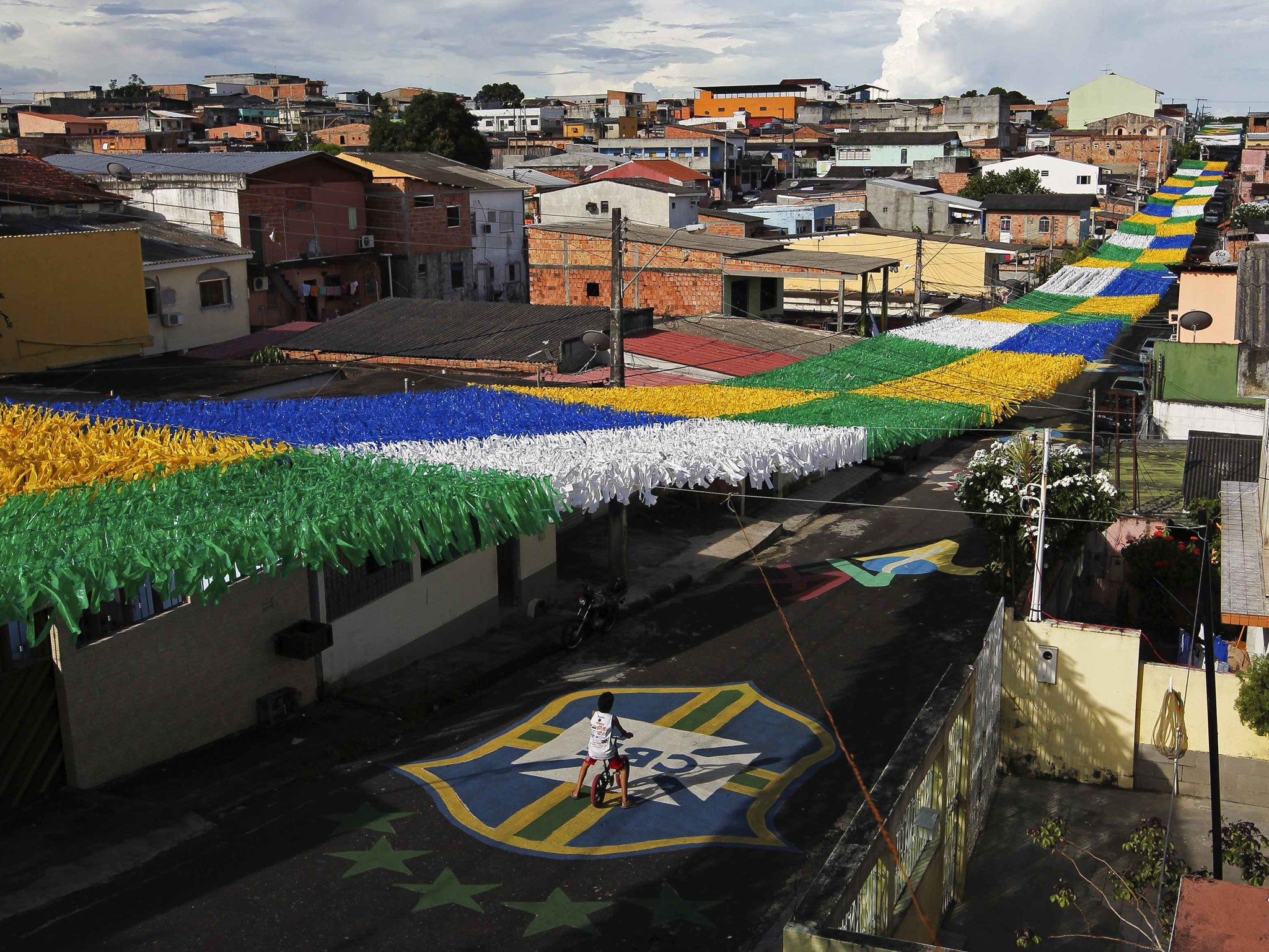 A boy rides his bicycle along Third Street of the Alvorada neighbourhood which is decorated for the 2014 World Cup in Manaus, one of the tournament's host cities