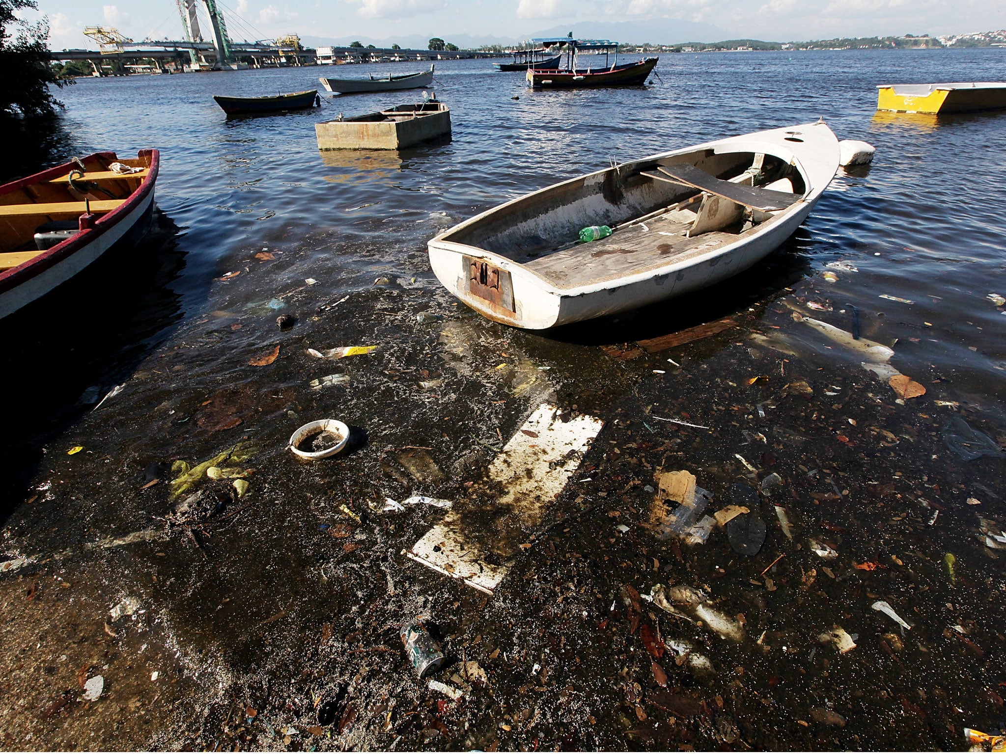 Boats float along the shoreline of the polluted waters of Guanabara Bay