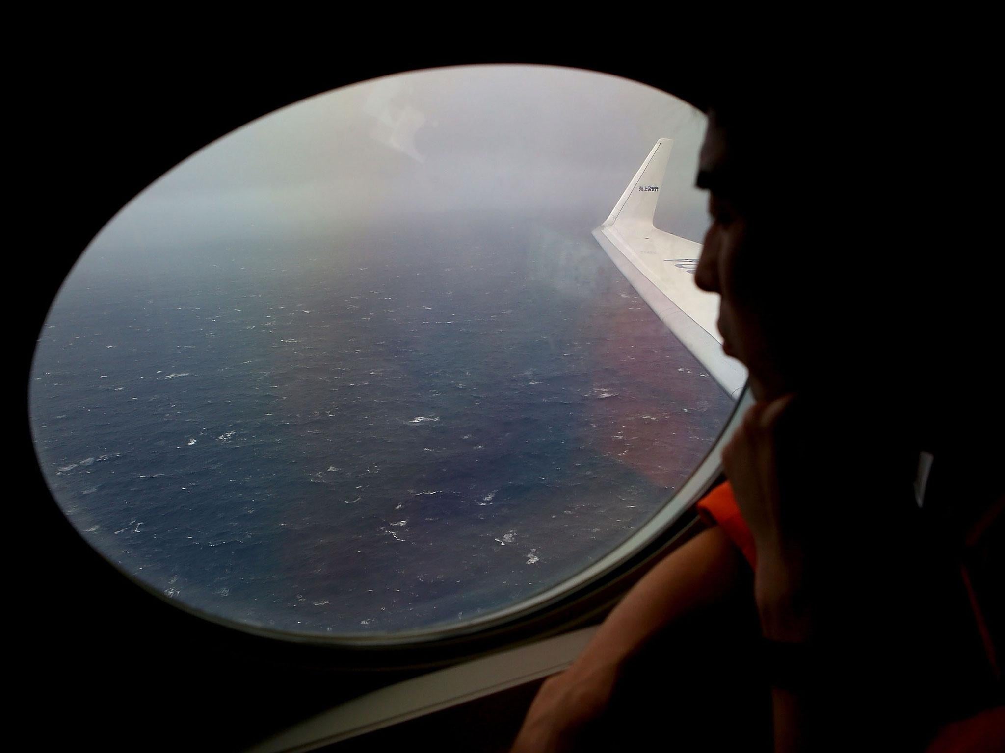 In a file picture taken on 1 April, Koji Kubota of the Japan Coast Guard keeps watch for debris from the missing flight MH370