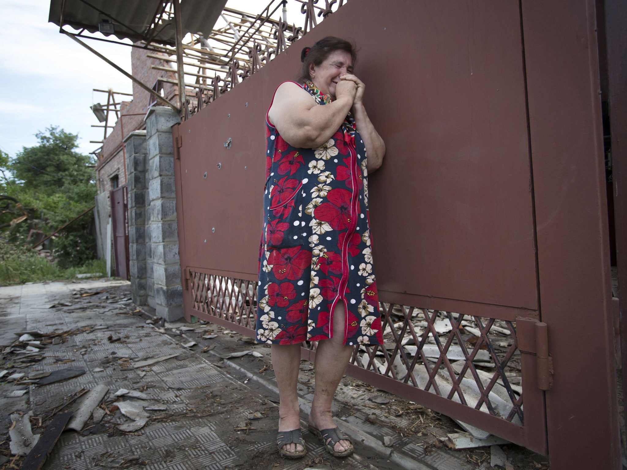 Yekaterina Len (61) cries outside her ruined house in Slavyansk