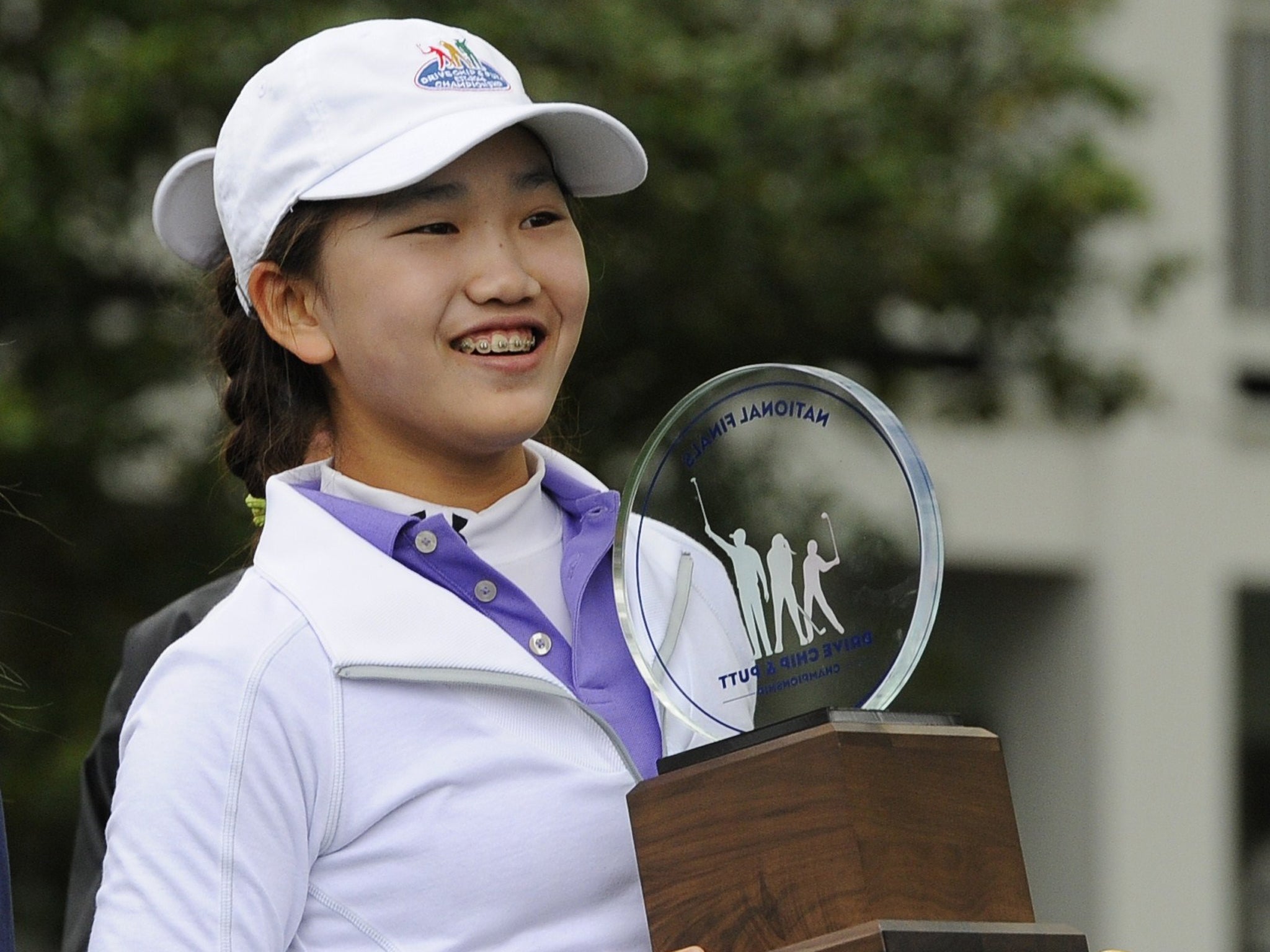 Girls 10-11 category champion Lucy Li from Redwood City, California poses with her trophy during the National Finals of the 2014 Drive, Chip and Putt Championships April 6, 2014 at Augusta National