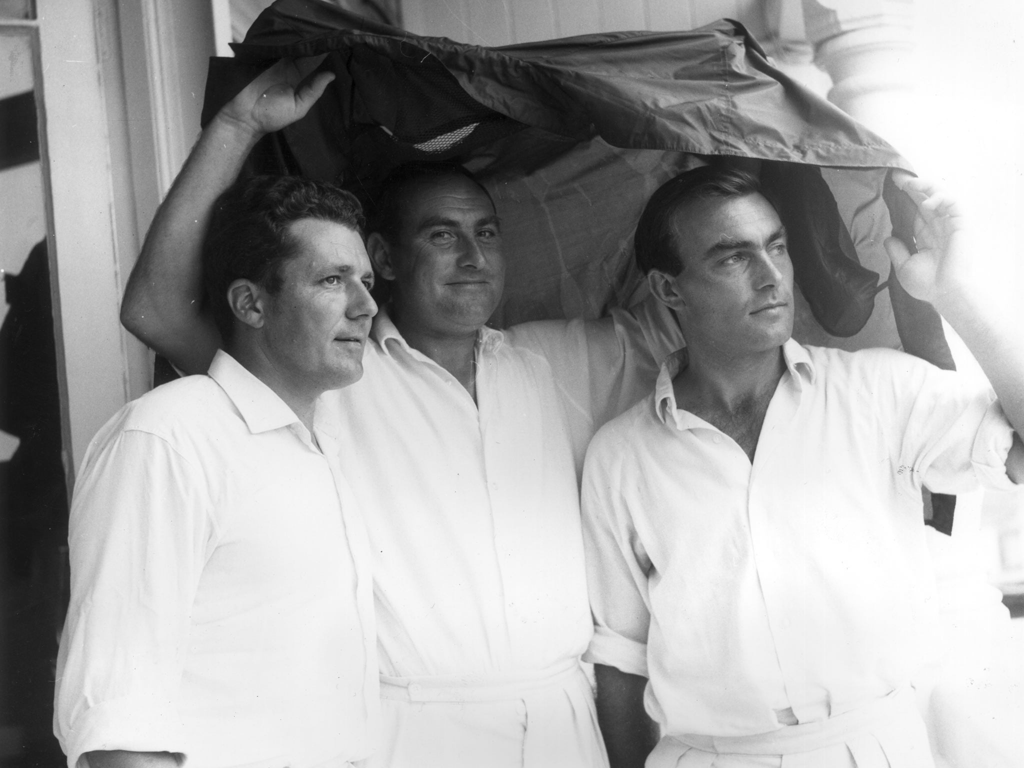 England test captain John Edrich and two century-making batsmen Phil Sharpe and Ray Illingworth take shelter as rain stops play in the Second Test against New Zealand at Trent Bridge