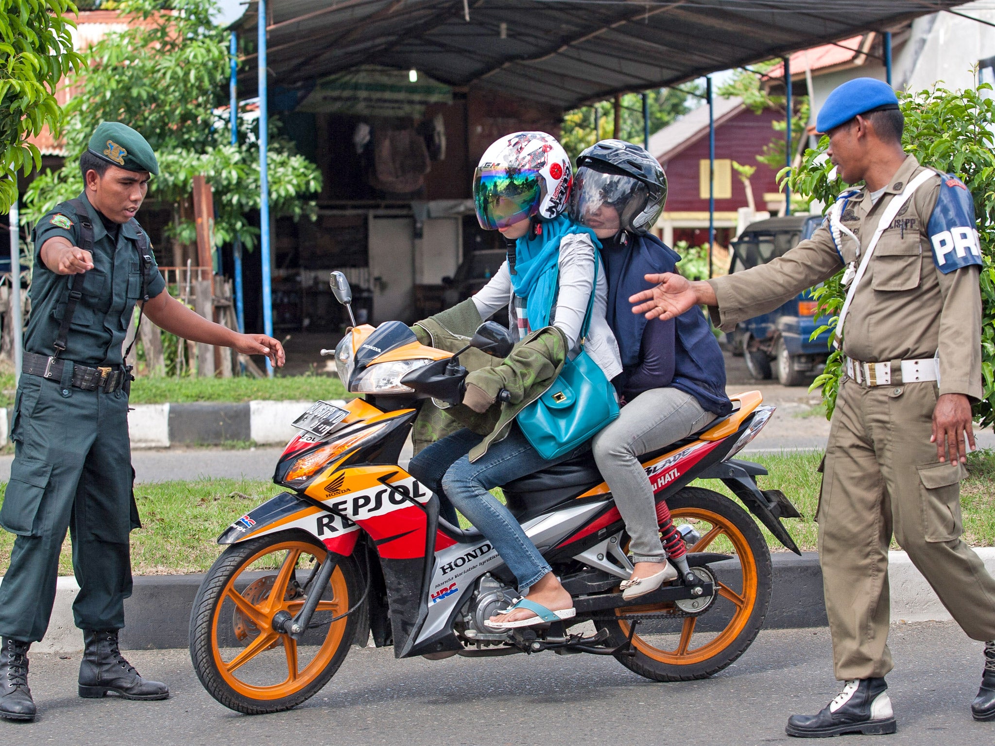 Sharia police stop a couple during an operation against women wearing tight jeans in Banda Aceh