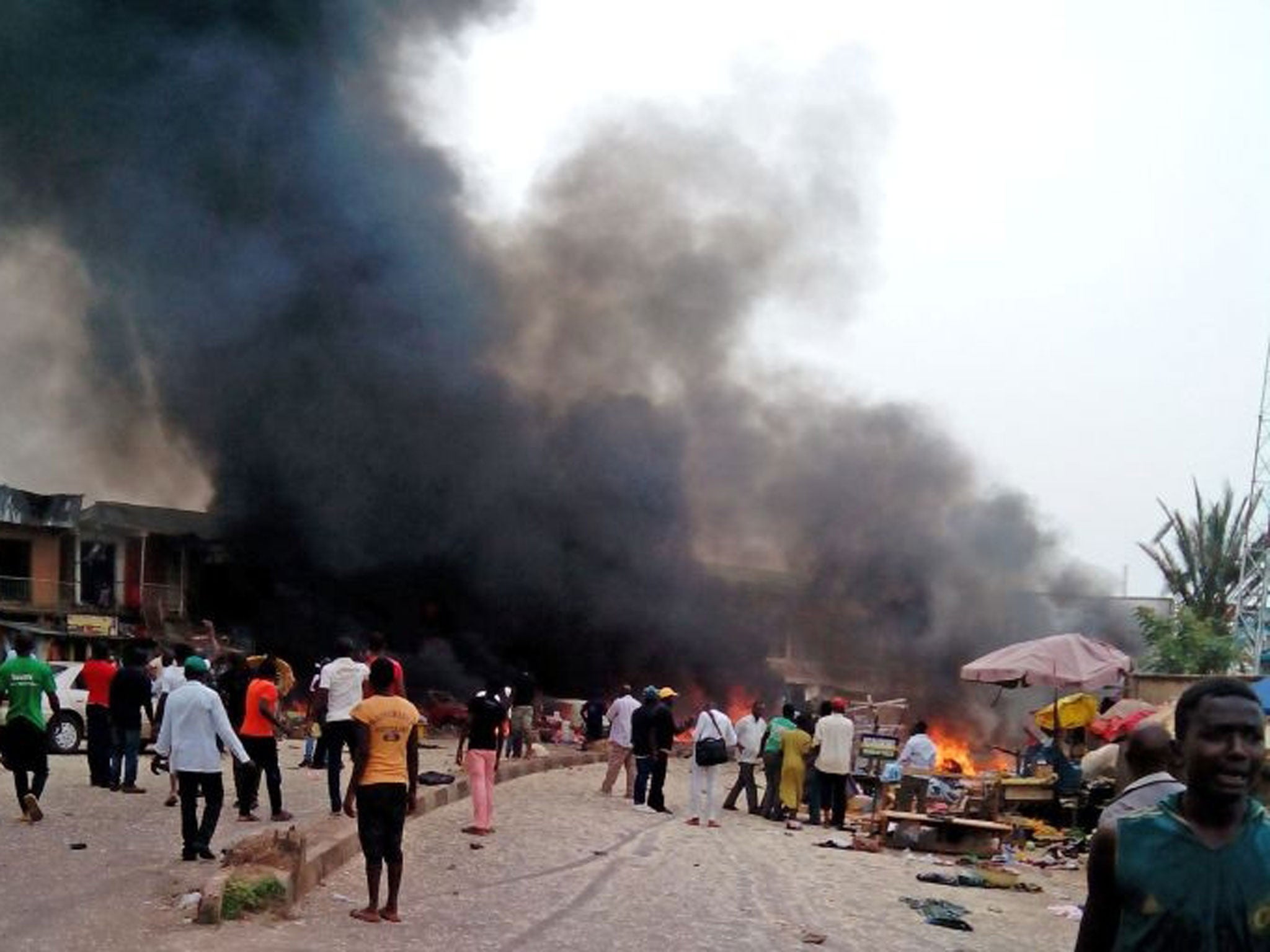 Smoke rises after a bomb blast at a bus terminal in Jos, Nigeria, Tuesday, May 20, 2014. Two explosions ripped through a bustling bus terminal and market frequented by thousands of people in Nigeria's central city of Jos on Tuesday afternoon, and police s