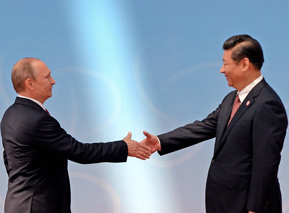 Russian President Vladimir Putin and Chinese President Xi Jinping shake hands in Shanghai