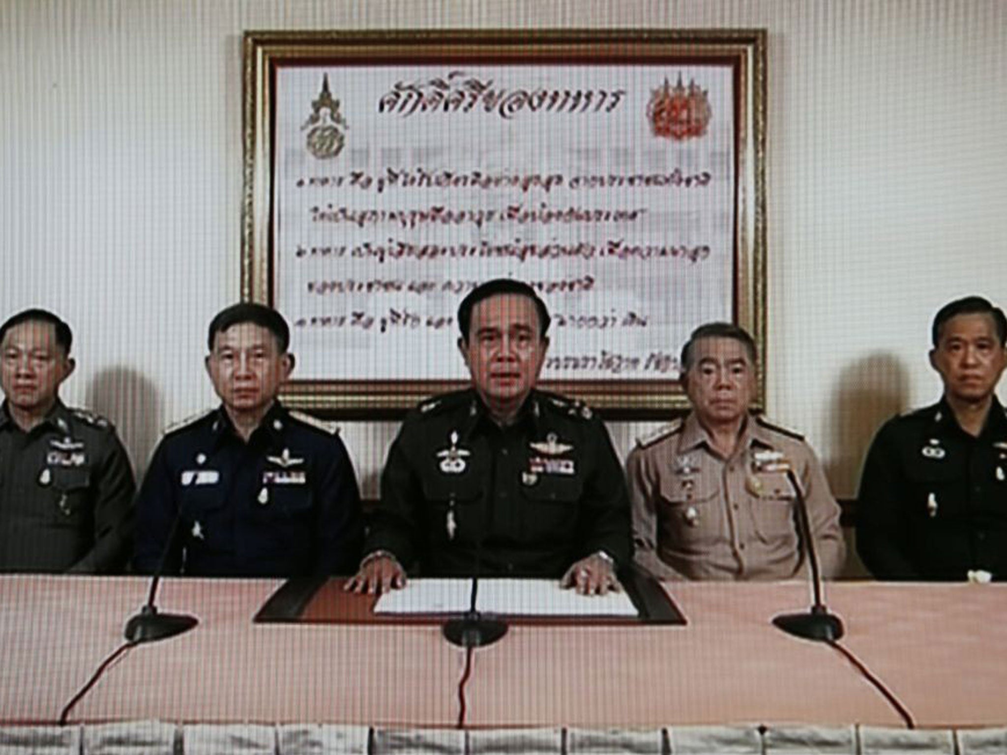 TV grab shows Army Chief General Prayuth Chan-ocha (C) speaking next to Navy Chief Adm Narong Pipattanasai (2-R), Air Chief Marshall Prachin Chantong (2-L), Thai Police Chief Adul Saengsingkaew (L) and identified high rank military officer (R) during a mi