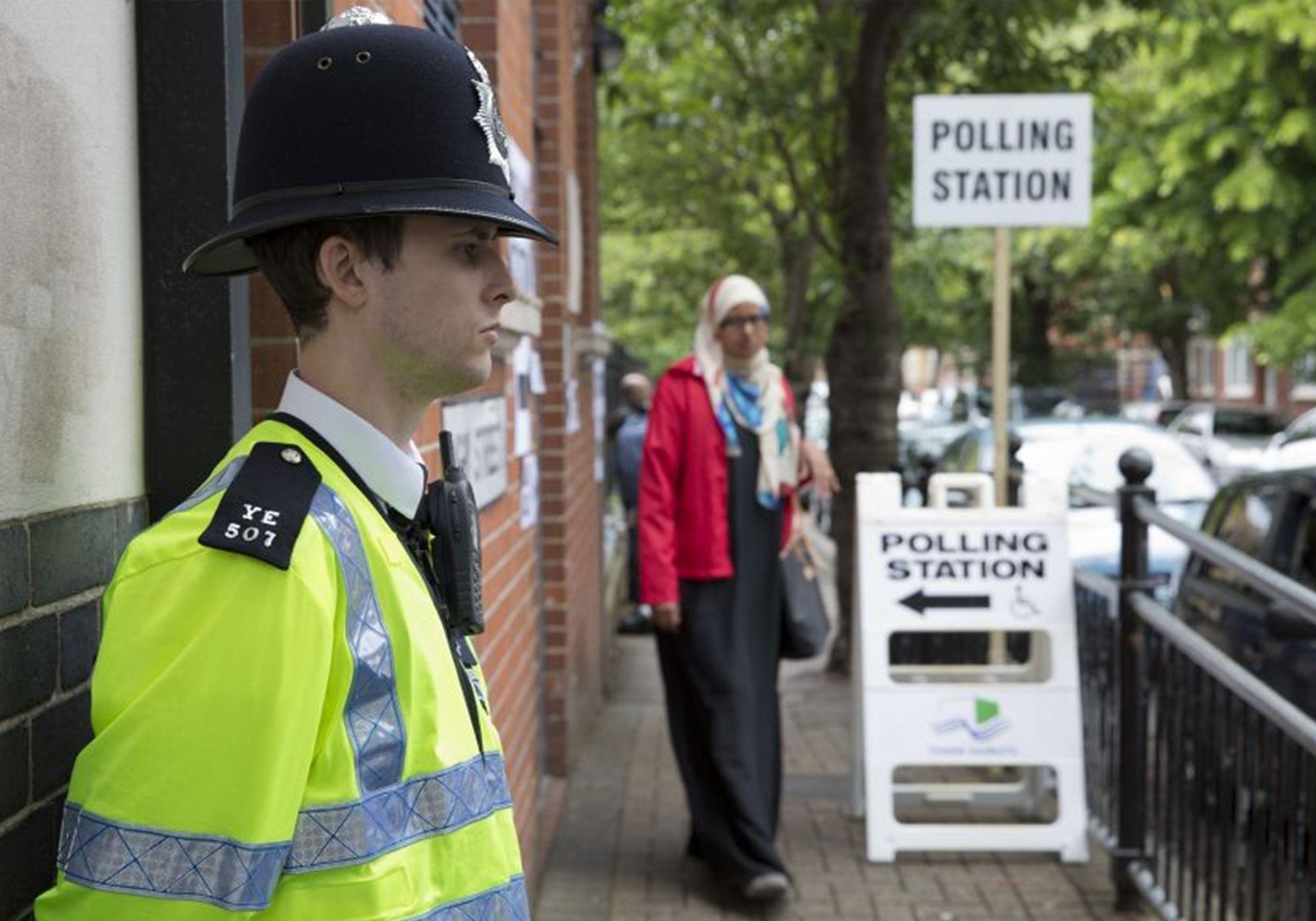 A police officer stands outside a polling station in Tower Hamlets, east London