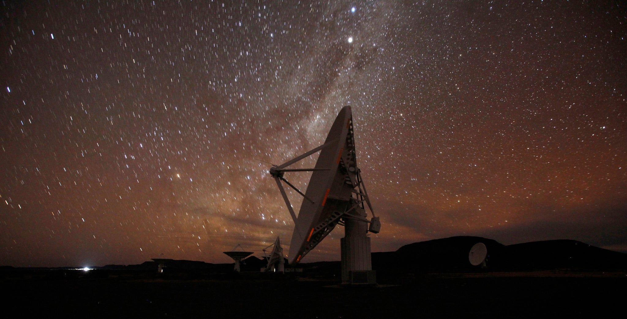 Night falls over radio telescope dishes of the KAT-7 Array at the proposed South African site for the Square Kilometre Array (SKA) telescope
