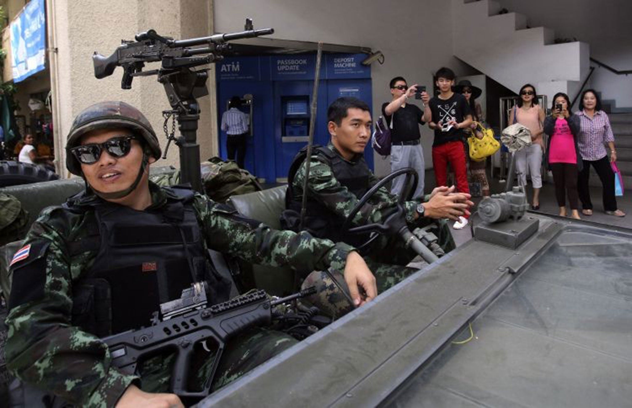 Tourists photograph soldiers outside the Thai police headquarters in Bangkok