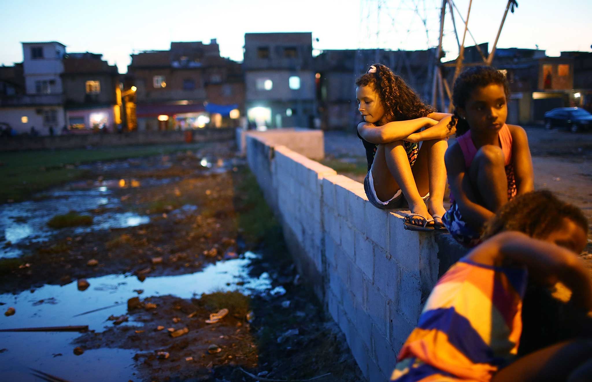 Children play near a former football field in the Manguinhos 'favela' in Rio de Janiero