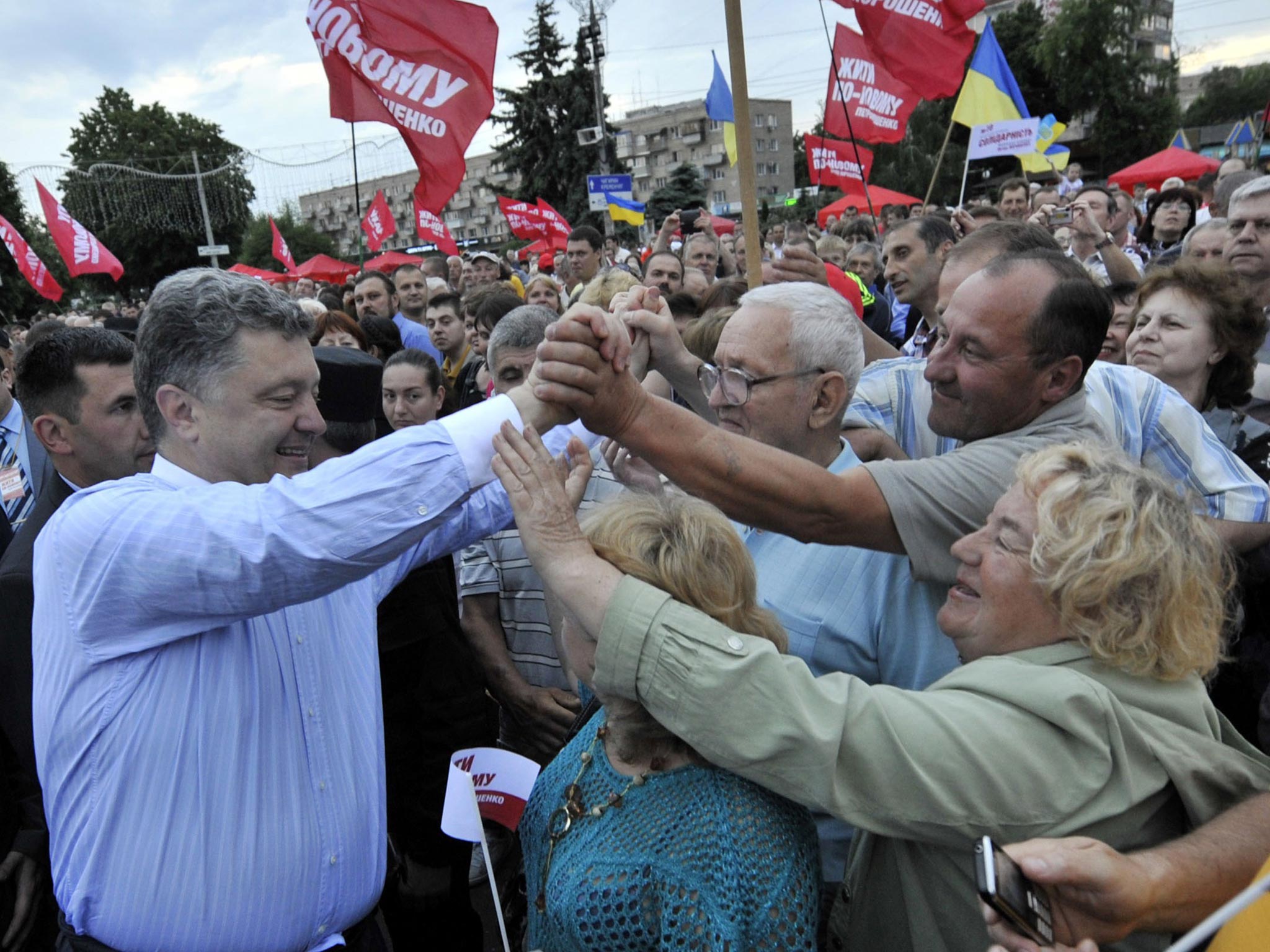 This handout picture released by the Poroshenko press service shows Ukrainian independent presidential candidate Petro Poroshenko (L) being greeted by supporters