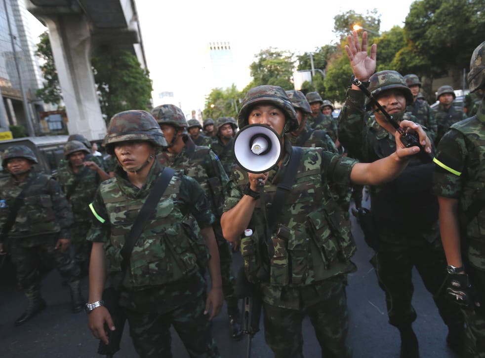 Soldiers try to control the crowd during a protests against military rule in central Bangkok