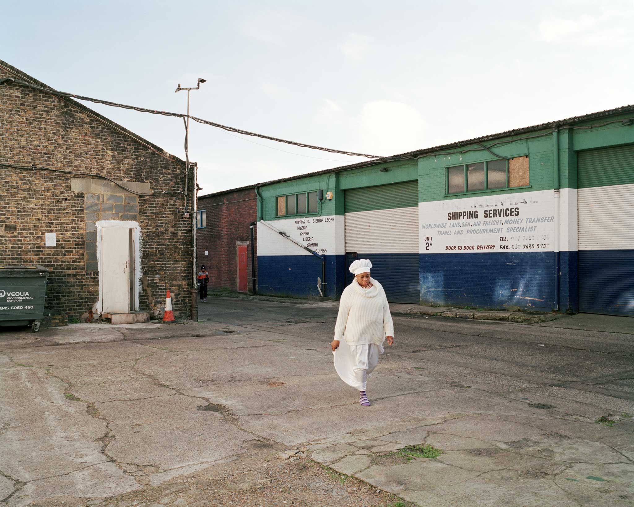A woman walks to church through the Copeland Park Industrial Estate in Peckham. There are said to be 11 churches, within this one industrial estate.