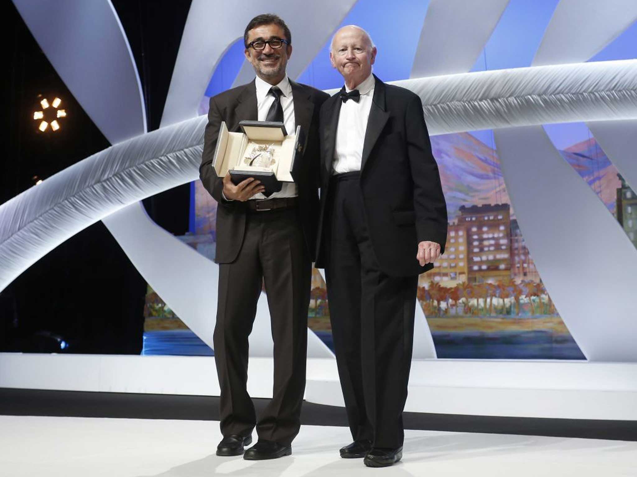 Turkish director Nuri Bilge Ceylan (L) poses with Festival President Gilles Jacob (R) after winning the Palme d'Or