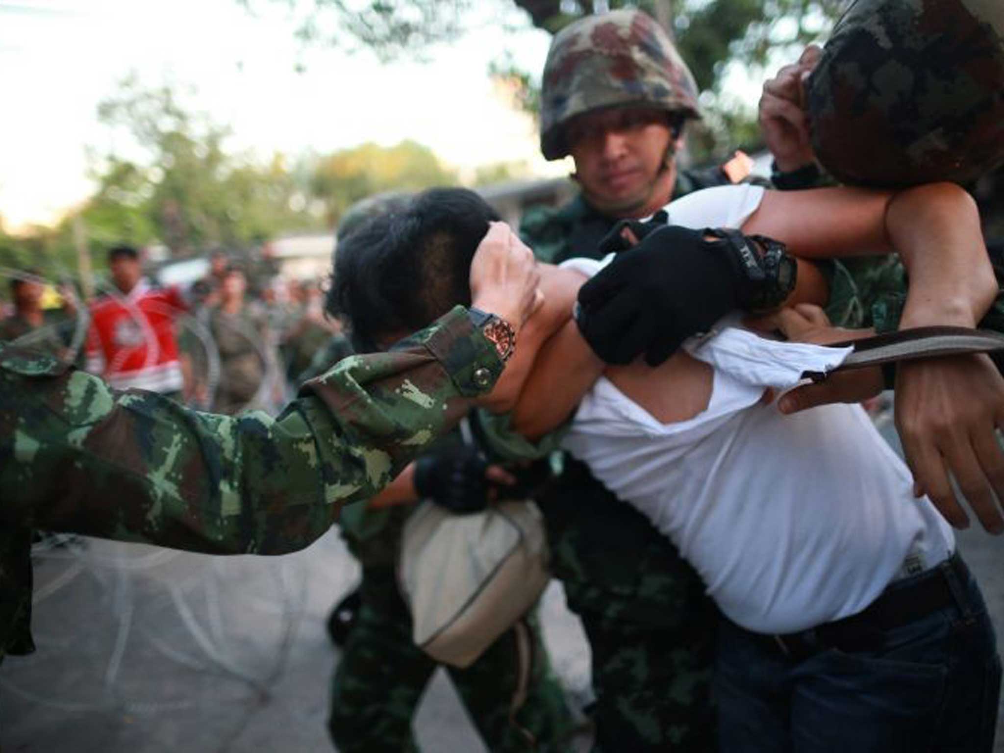 Soldiers grapple with a protester