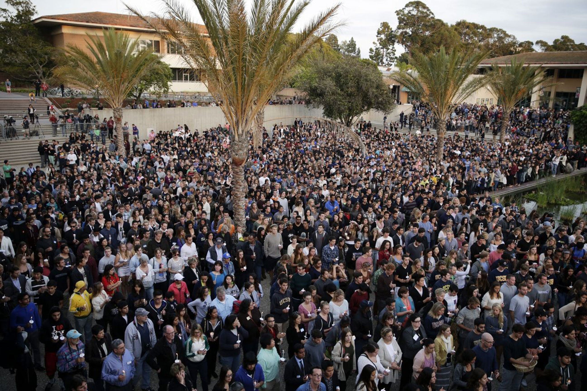 People stand during a candlelight vigil held to honor the victims of the massacre on the campus of the University of California, Santa Barbara