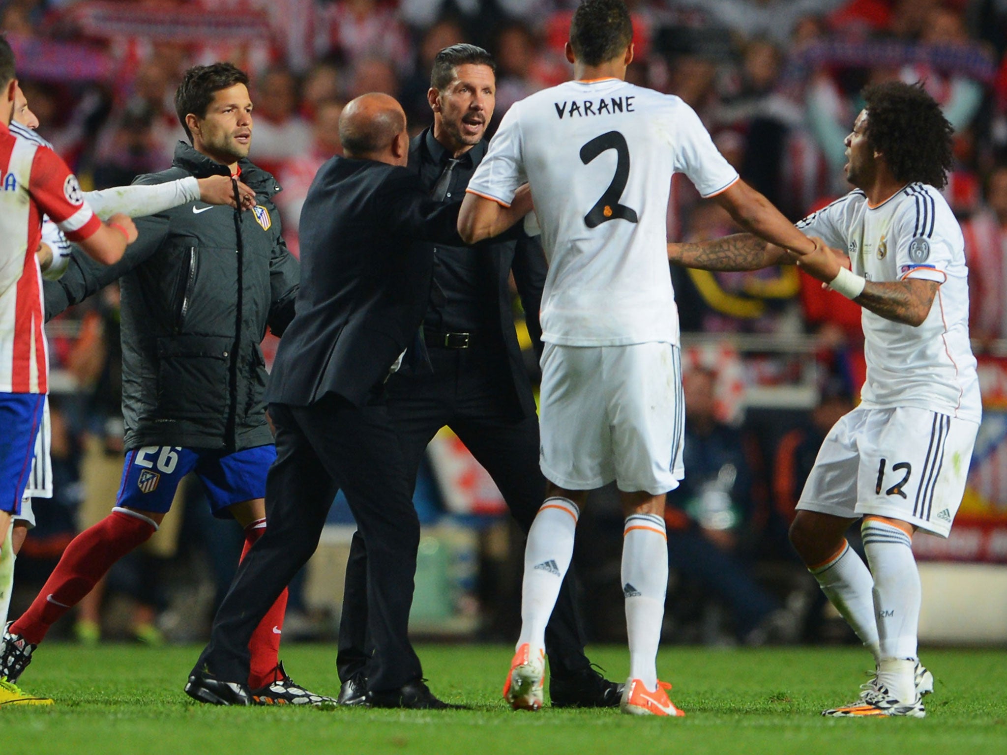 Atletico Madrid manager Diego Simeone (centre) clashes with Real Madrid defender Raphael Varane