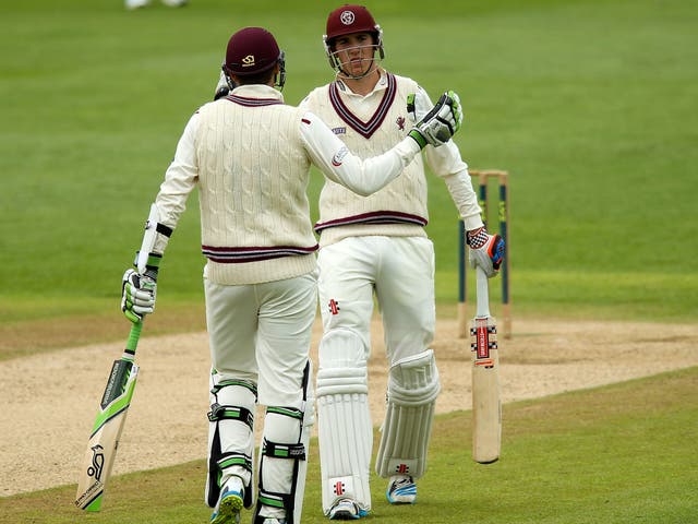 Jamie Overton of Somerset is congratulated by his brother, Craig, after hitting a maiden half-century 