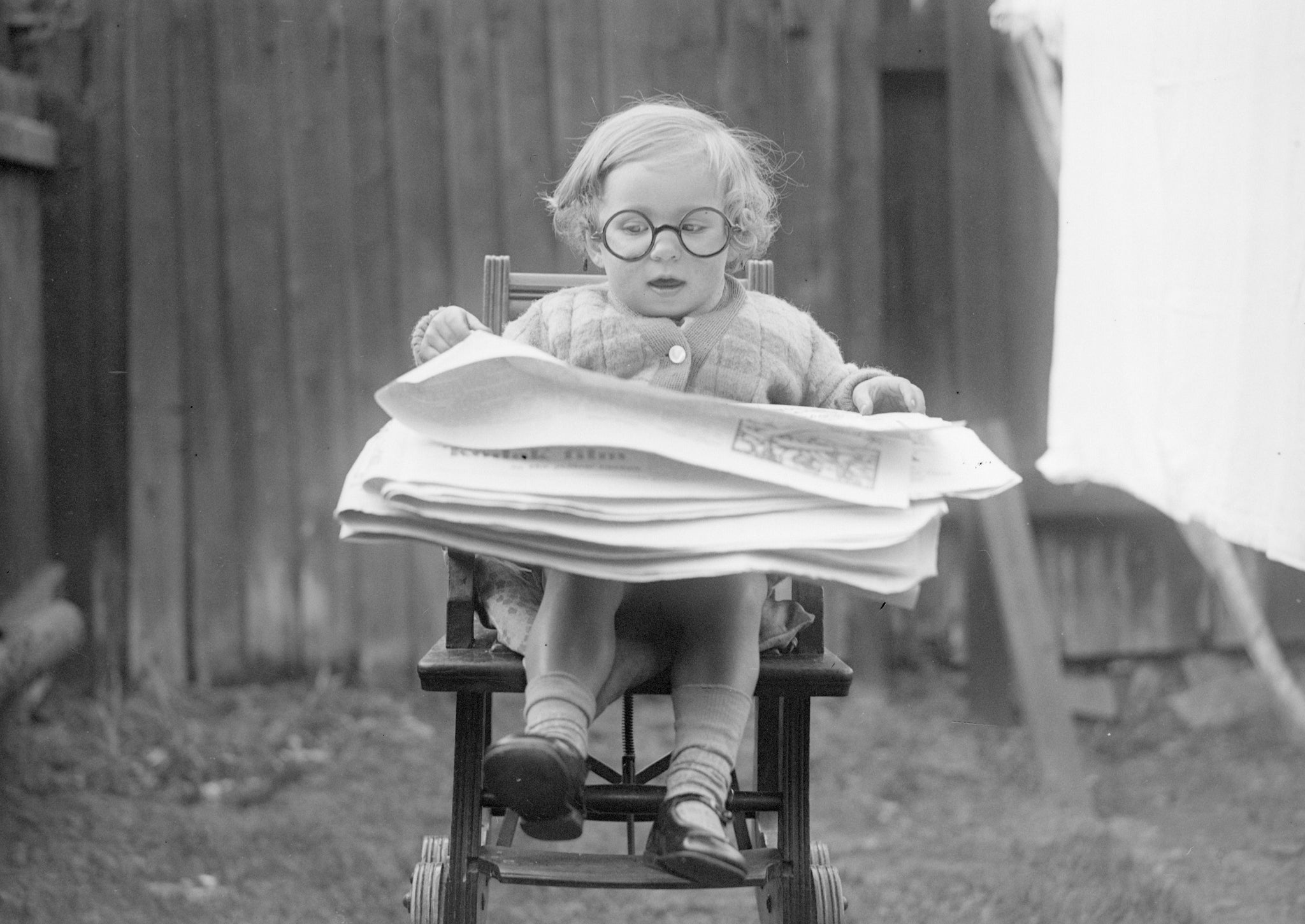 A smart baby reads a newspaper