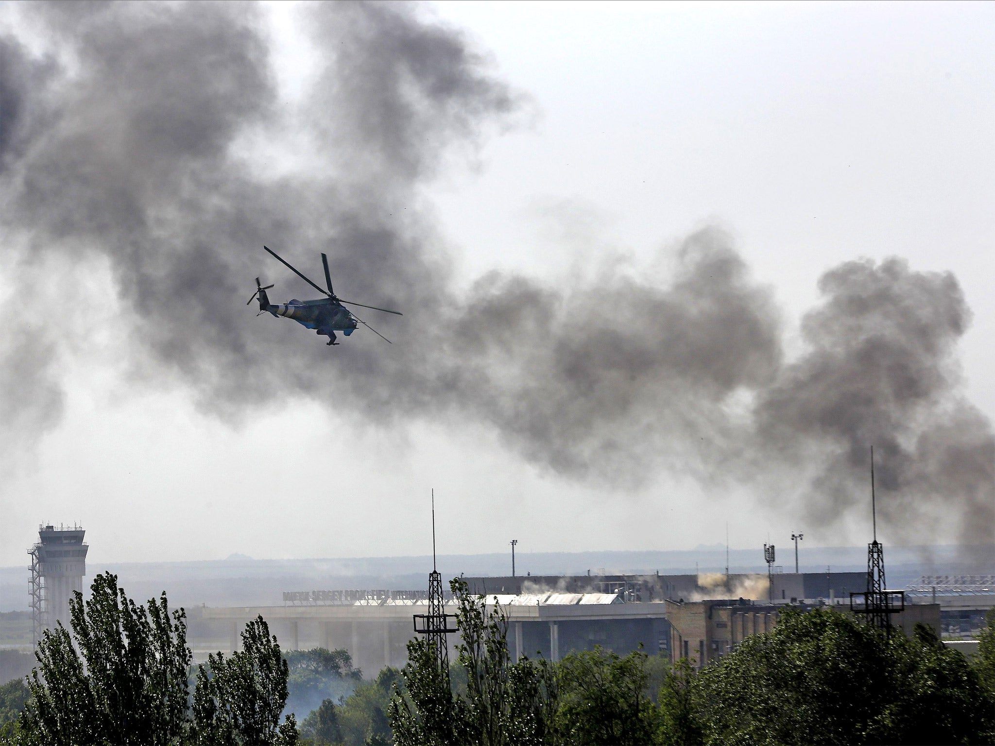 A Ukrainian helicopter Mi-24 gunship fires its canons against rebels at the main terminal building of Donetsk international airport