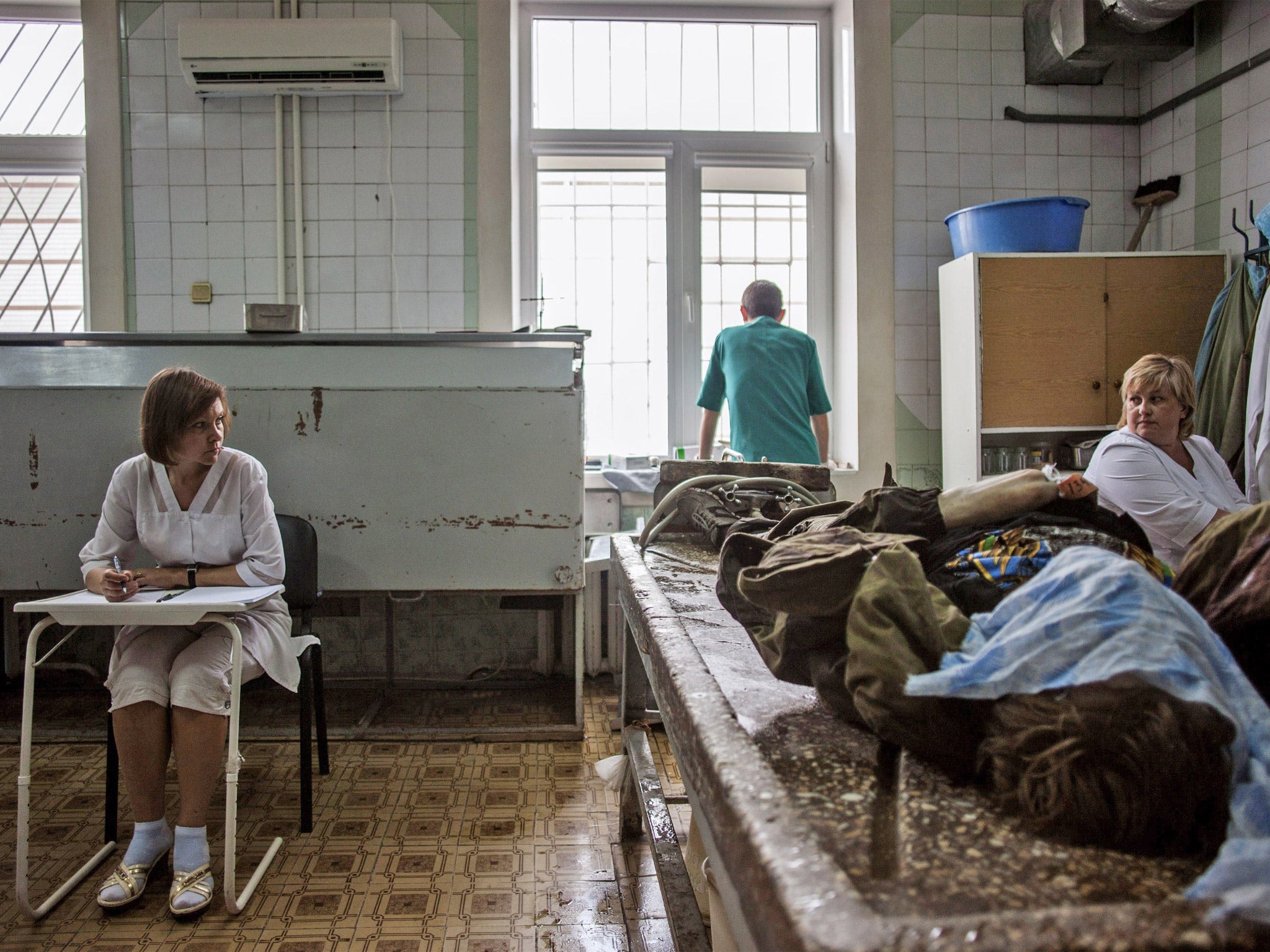 Medical staff at the Kalinina morgue in Donetsk prepare to attend to the body of a pro-Russian fighter (Getty)