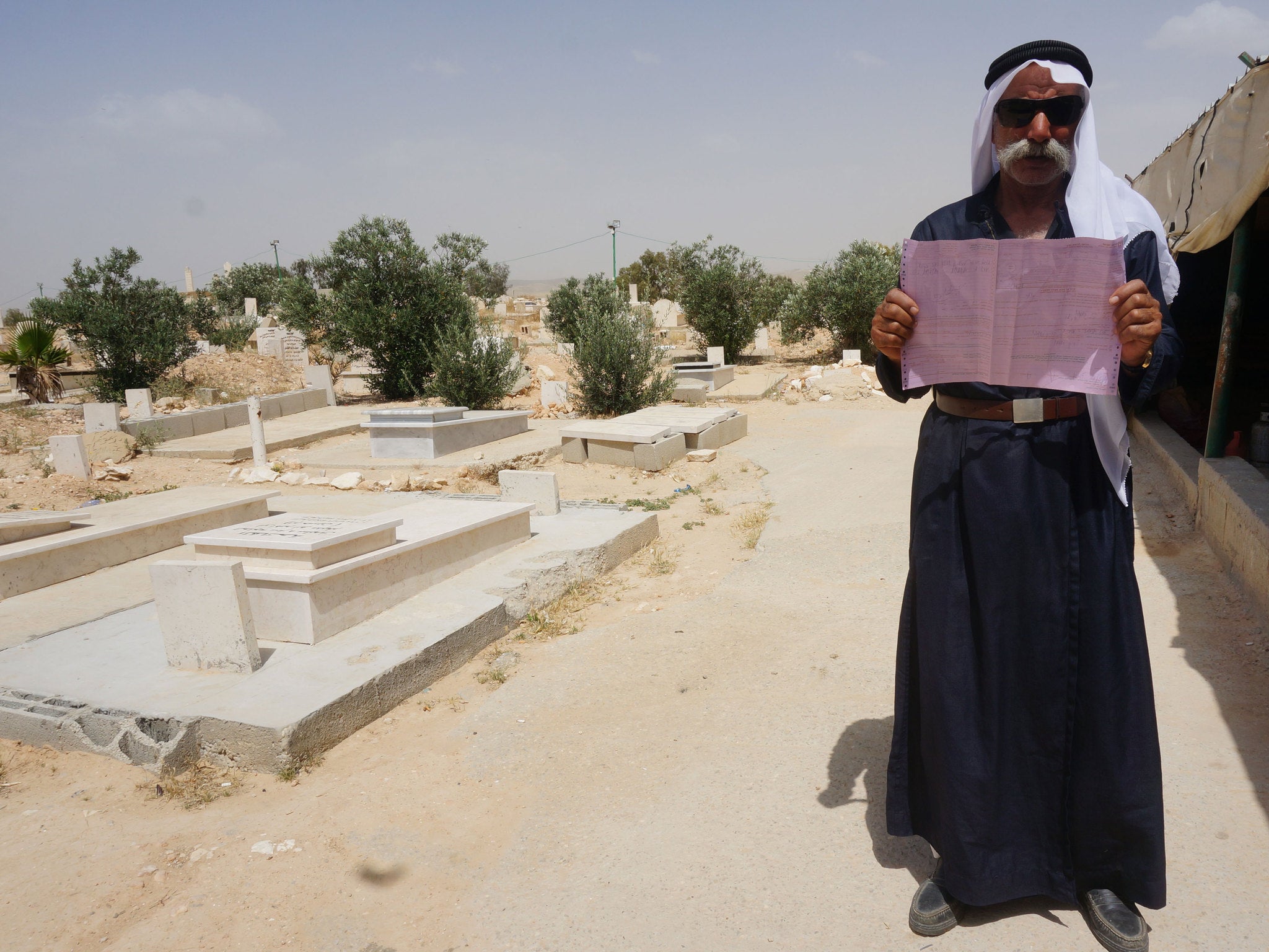Sayach Al-Turi in the cemetery with his eviction order.