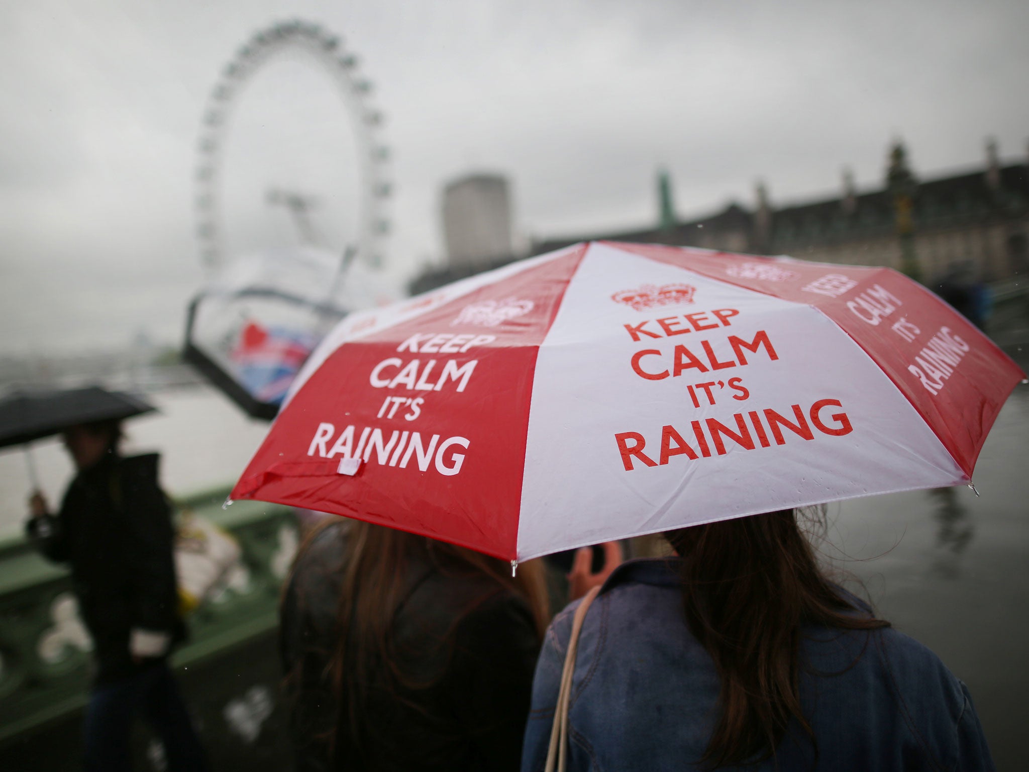 A girl carries a 'Keep calm it's raining' umbrella on Westminster Bridge on May 28, 2013 in London, England. Heavy rain is falling in London and the south east after a warm and sunny bank holiday weekend.