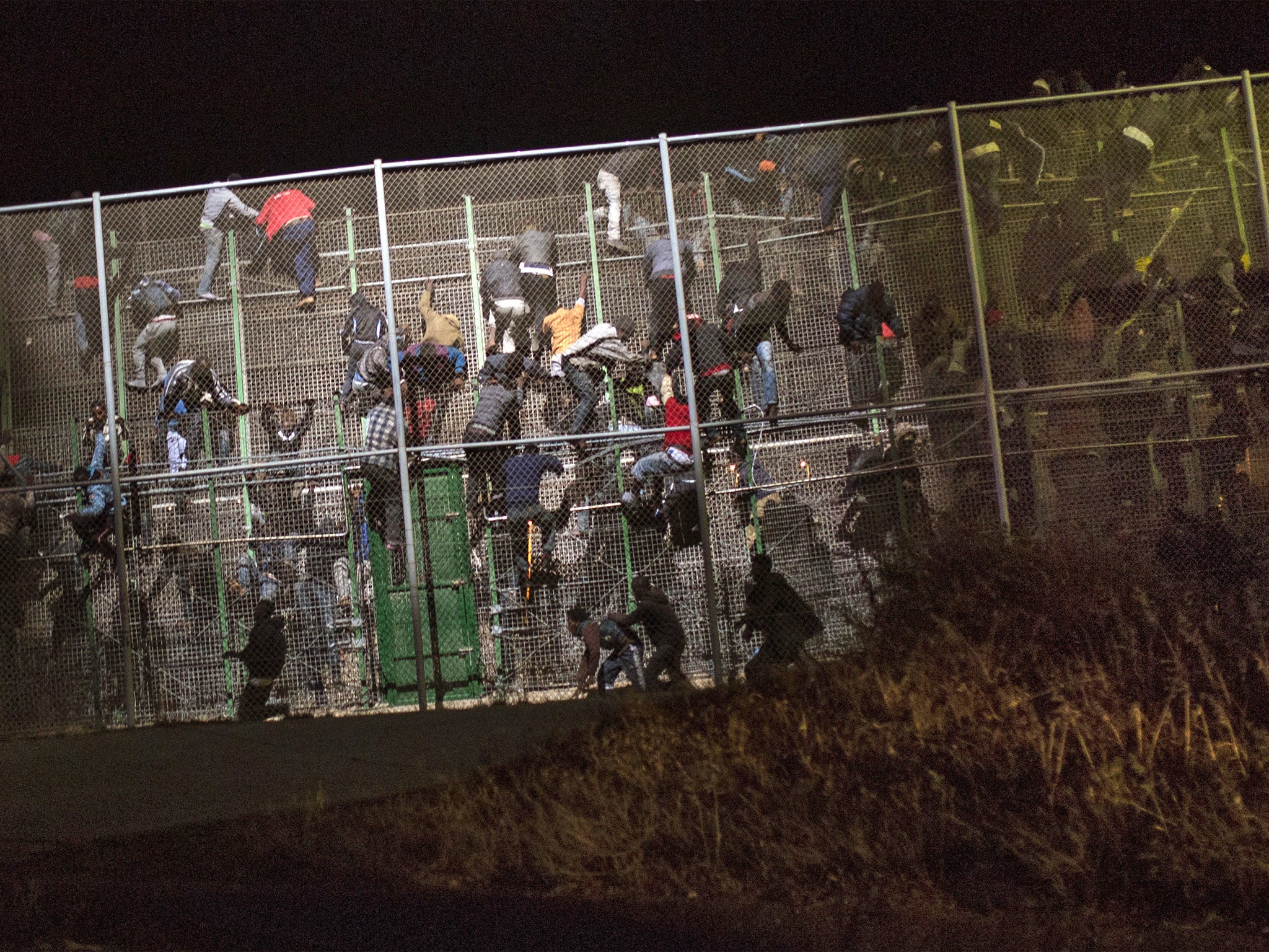 Would-be migrants scale a fence that divides Morocco and the Spanish enclave of Melilla