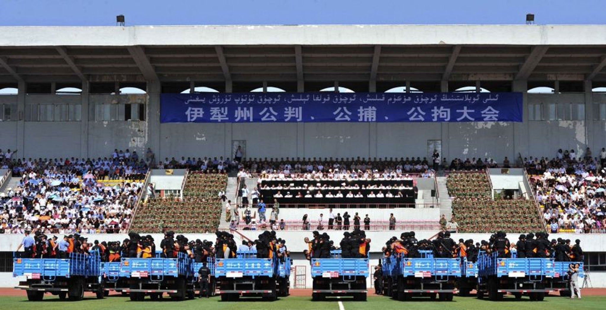 Trucks packed with criminals and suspects are seen during a mass sentencing rally at a stadium in Yili, Xinjiang Uighur Autonomous Region
