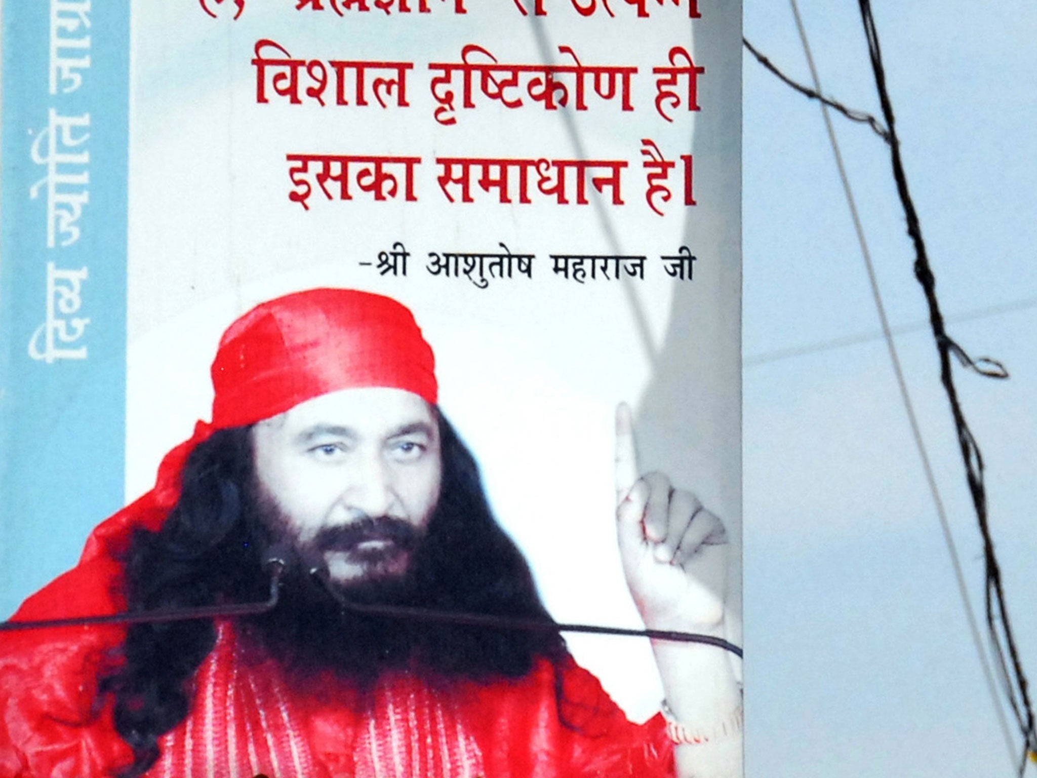 A poster featuring an image of Indian spiritual leader Shri Ashutosh Maharaj stands outside the Divya Jyoti Jagrati Sansthan in Nurmahal on the outskirts of Jalandhar on 11 March, 2014