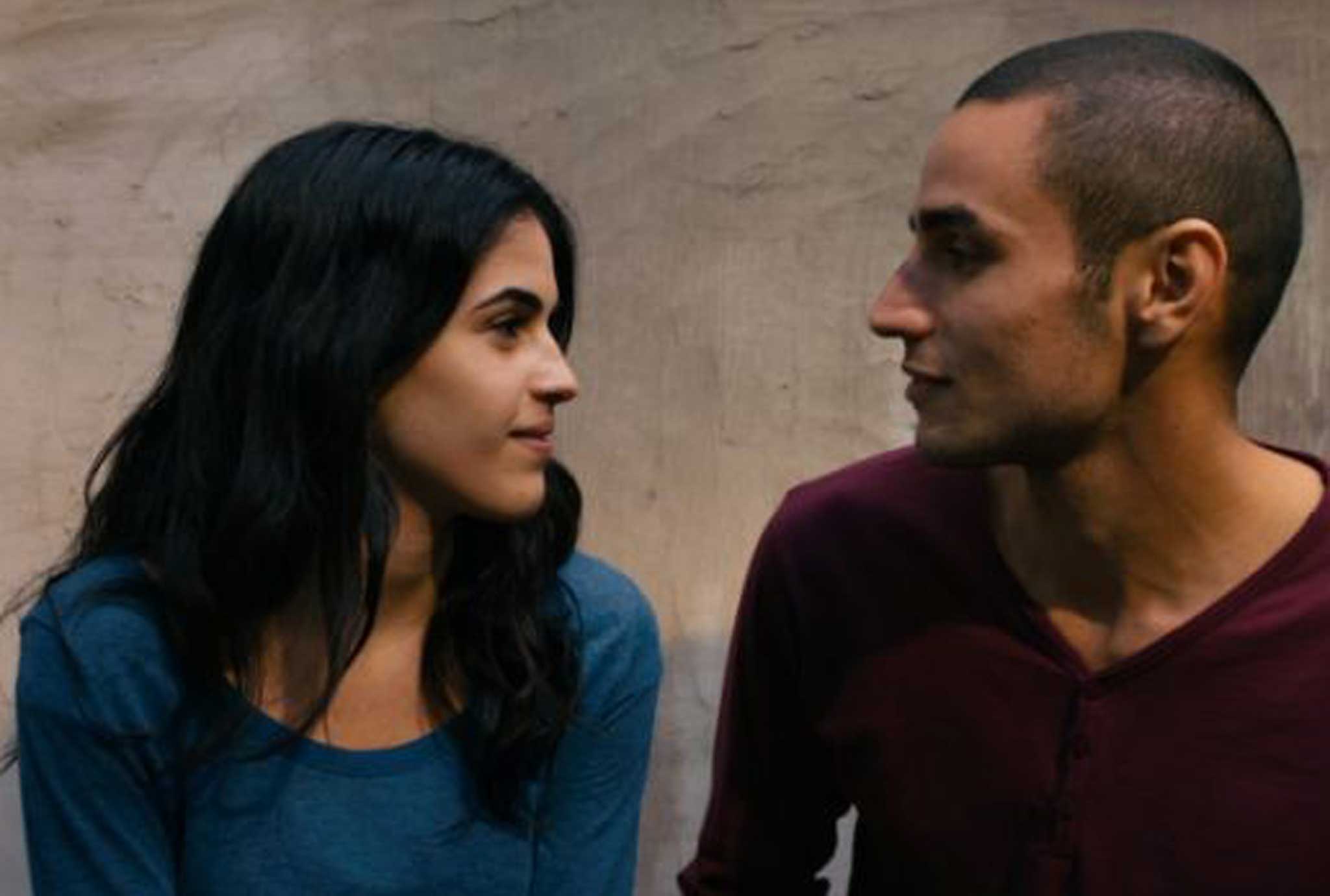 Secret tryst: Omar (Adam Bakri) scales the "isolation wall" to visit his friend's younger sister Nadia (Leem Lubany)