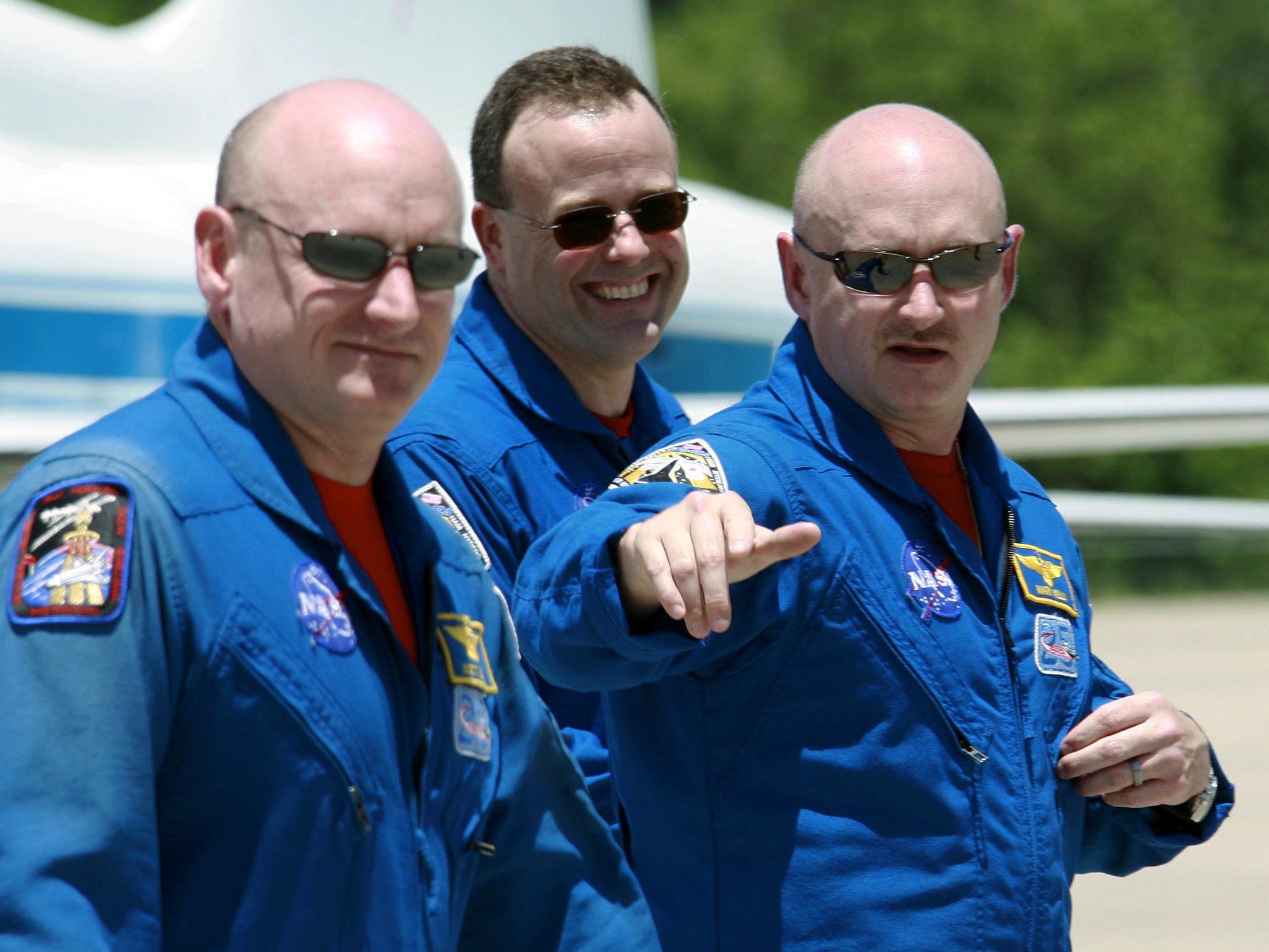 Shuttle Discovery commander Mark Kelly, right, gestures as he walks with his twin brother, astronaut Scott Kelly