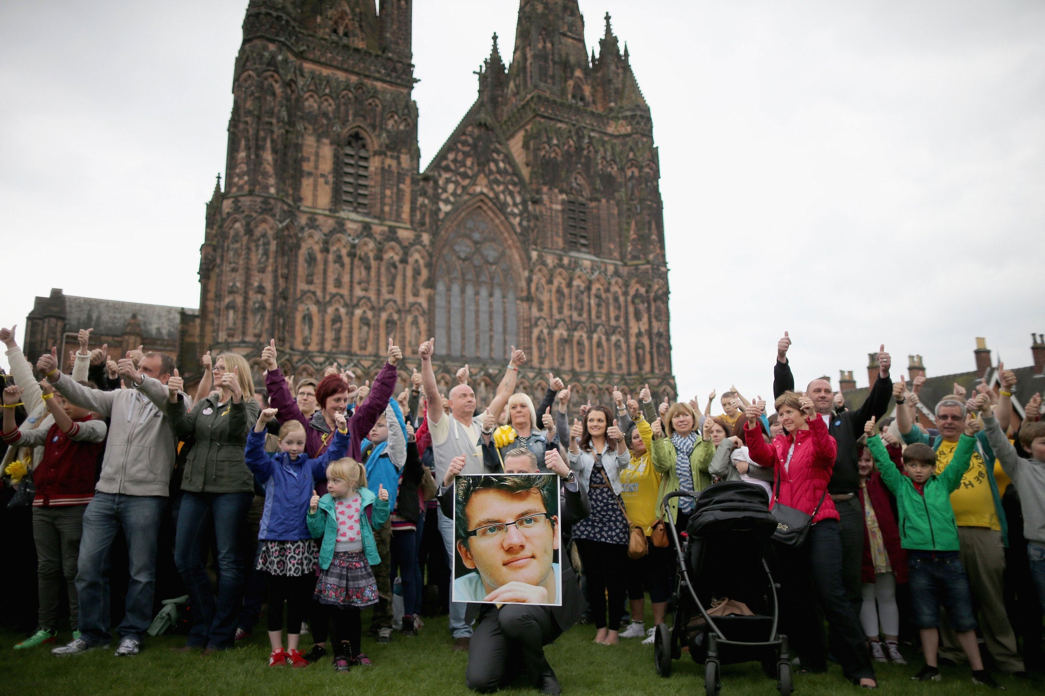 Members of the public take part in a minute of celebration and give the "Thumbs Up" sign for the life of teenage cancer fundraiser Stephen Sutton during a vigil at Lichfield Cathedral