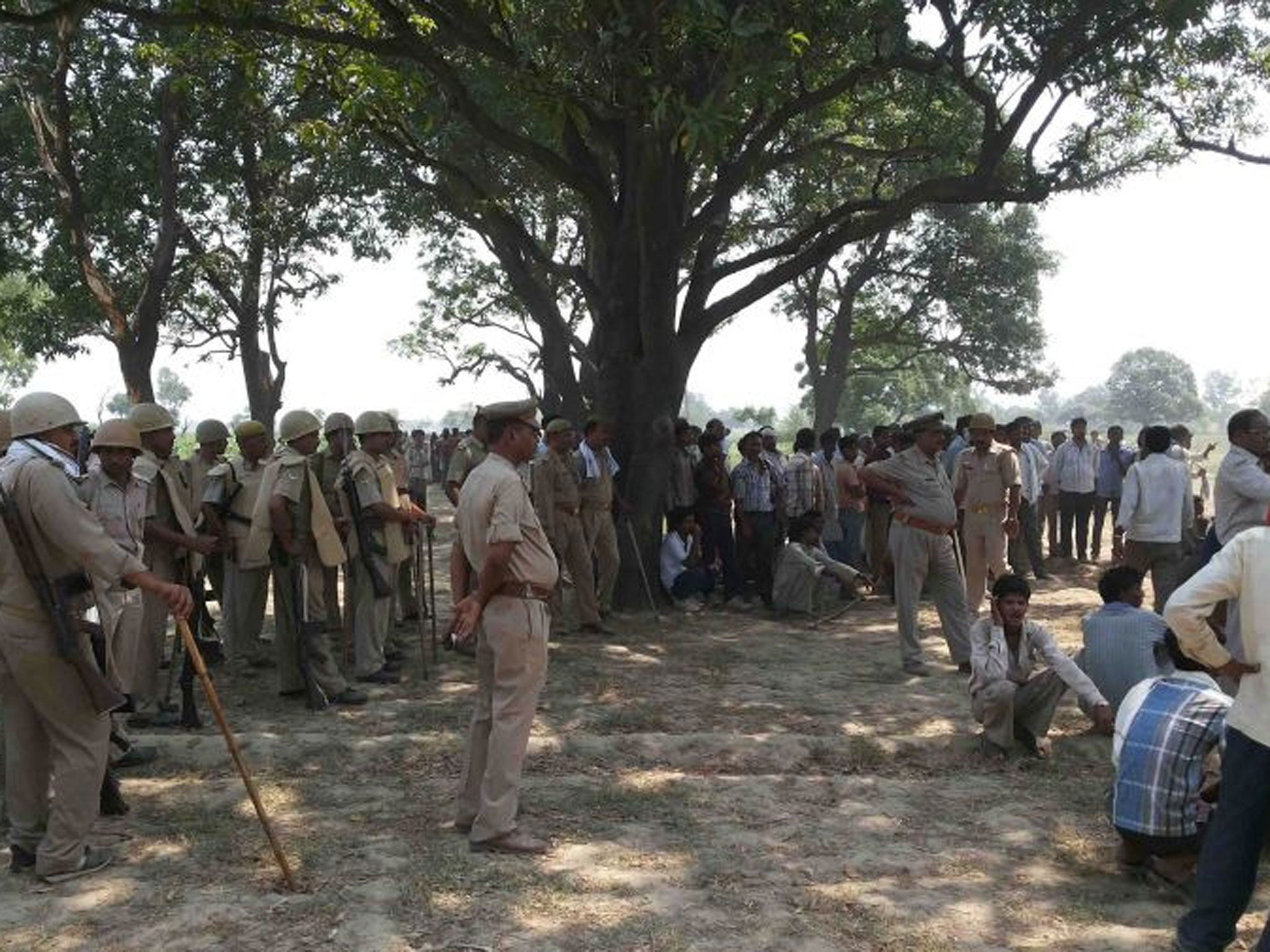 Villagers and policemen gather where two teenage cousins were found hanging