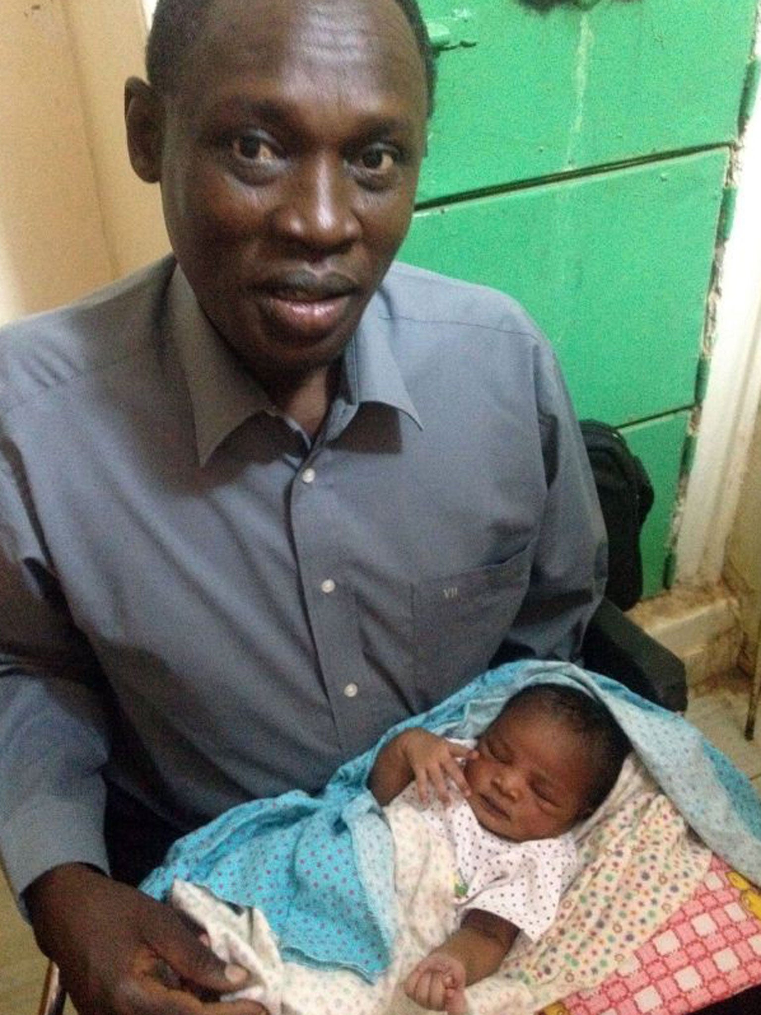 Daniel Wani, a US citizen originally from South Sudan, carrying his newborn daughter Maya at the womens prison in Khartoum's twin city of Omdurman