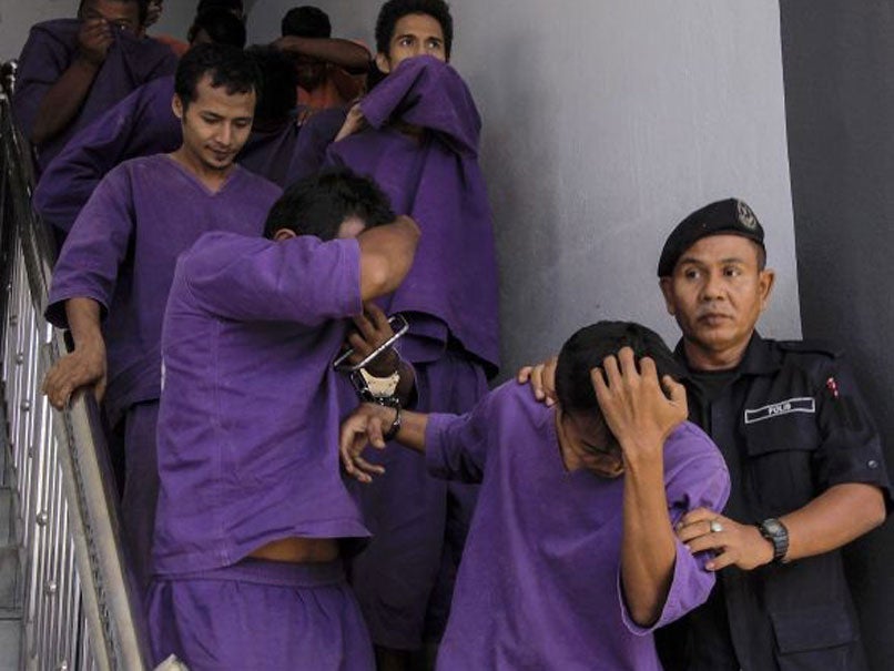 A picture made available 30 May 2014 shows Malaysian Police escorting gang-rape suspects to the courthouse in Kota Bharu, Kelantan, Malaysia, 29 May 2014.