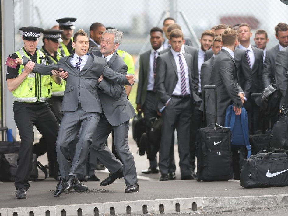Brodkin removed by security as he attempts to board the England football team's plane to the Brazil 2014 World Cup