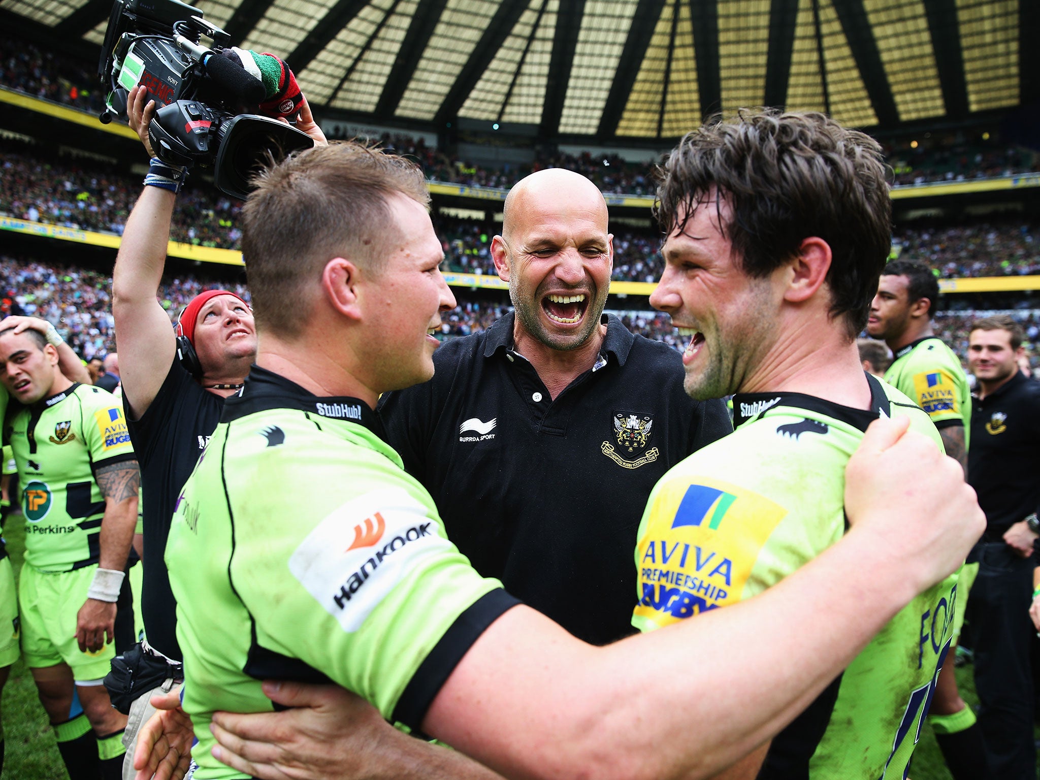 Northampton Saints players Dylan Hartley and Ben Foden celebrate with head coach Jim Mallinder