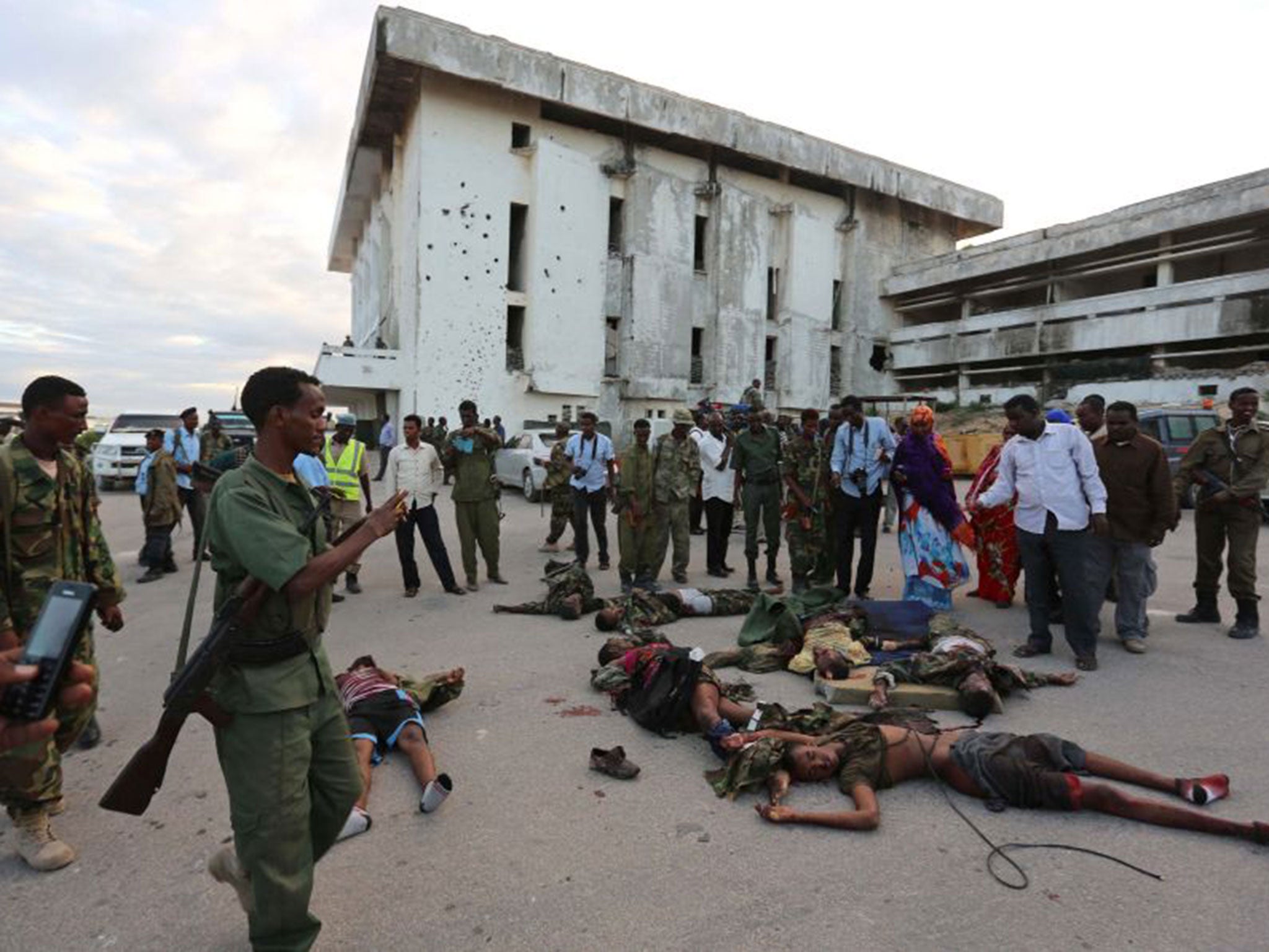 Somali soldiers displaying bodies of Al Shabaab fighters, killed during their attack on Parliament