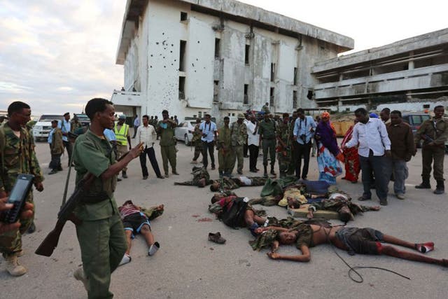 Somali soldiers displaying bodies of Al Shabaab fighters, killed during their attack on Parliament
