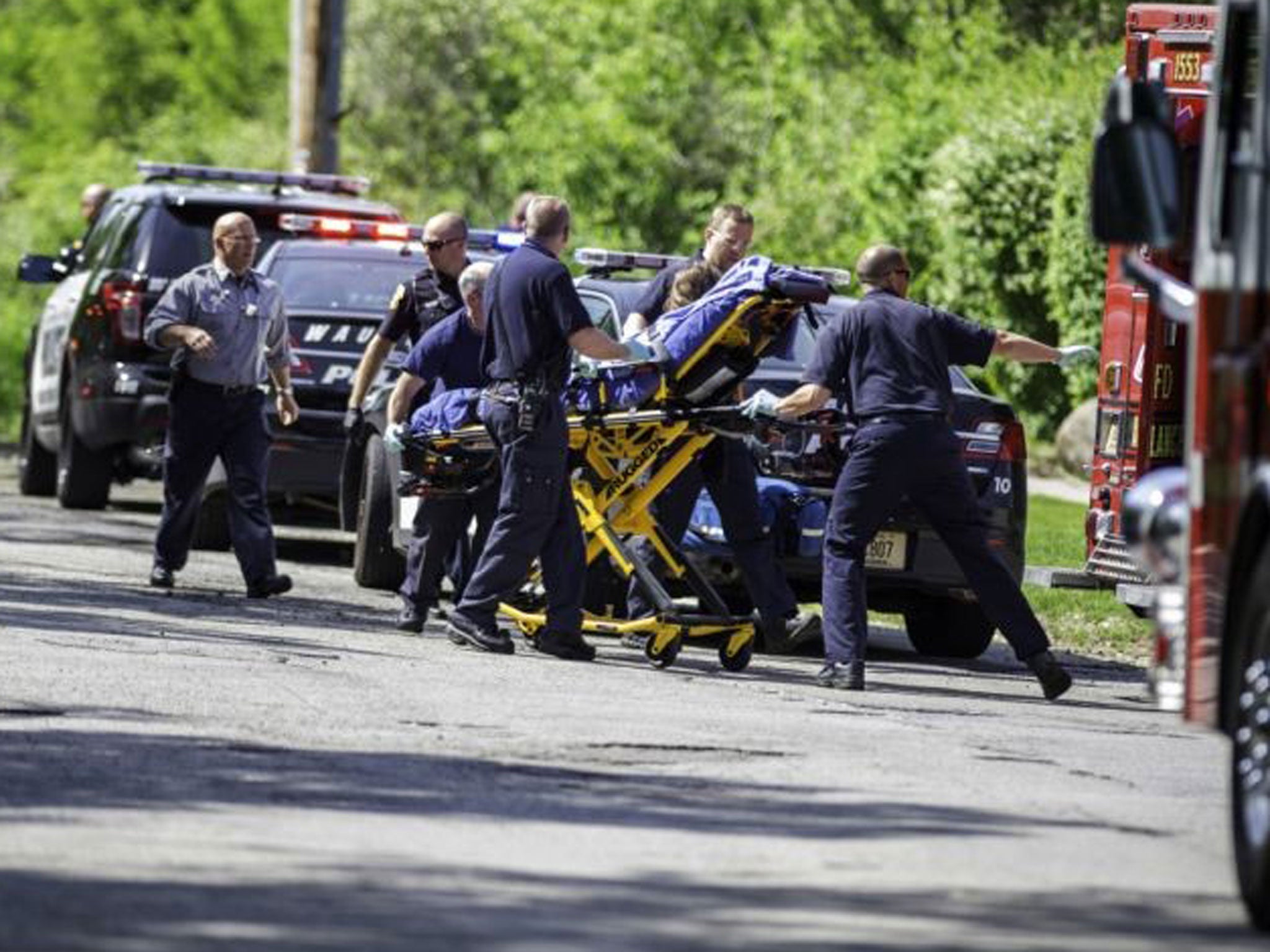 Rescue workers take a stabbing victim to the ambulance in Waukesha, Wis. Prosecutors say two 12-year-old southeastern Wisconsin girls stabbed their 12-year-old friend nearly to death in the woods to please a mythological creature they learned about online