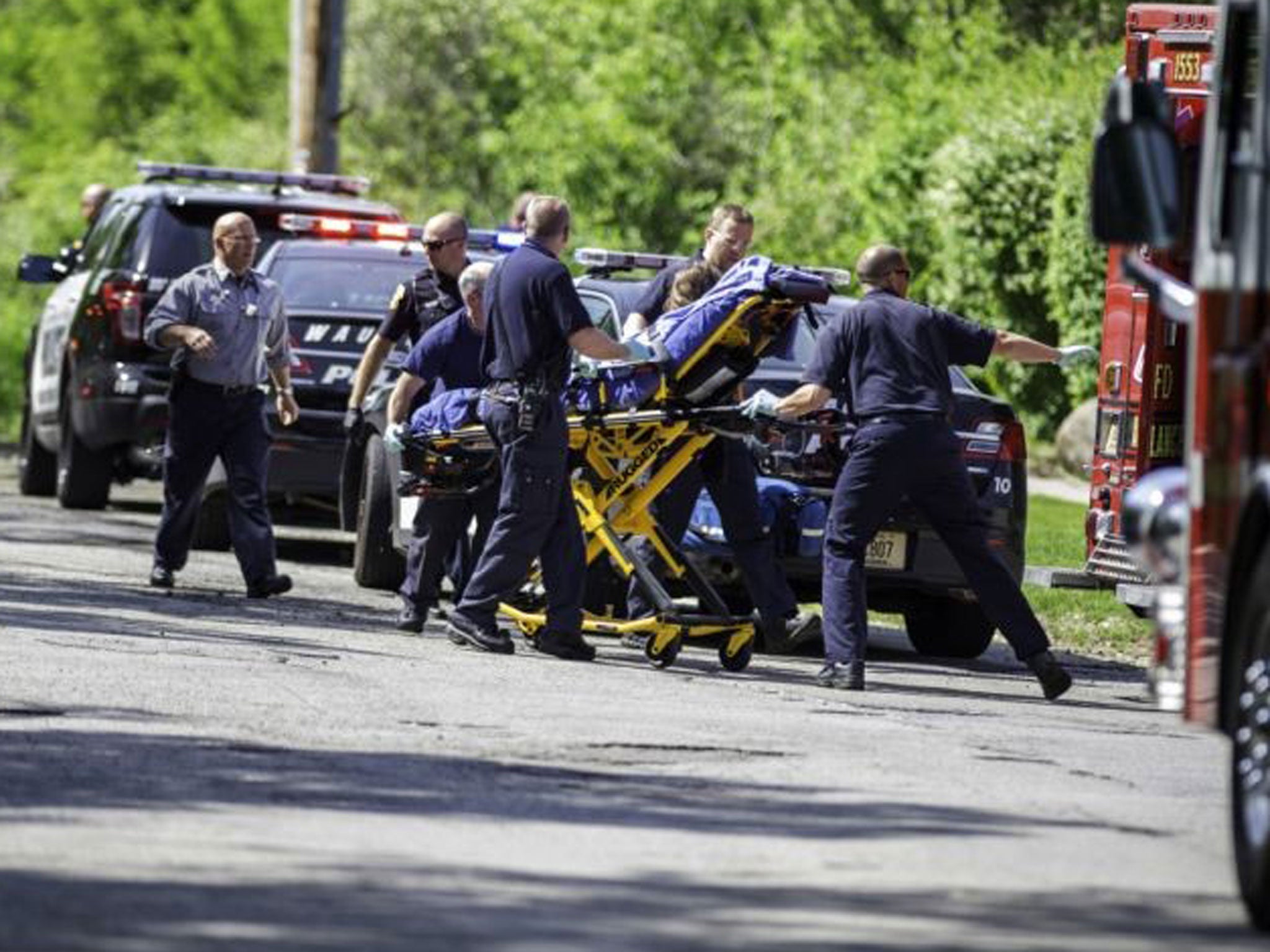 Rescue workers take a stabbing victim to the ambulance in Waukesha, Wis.