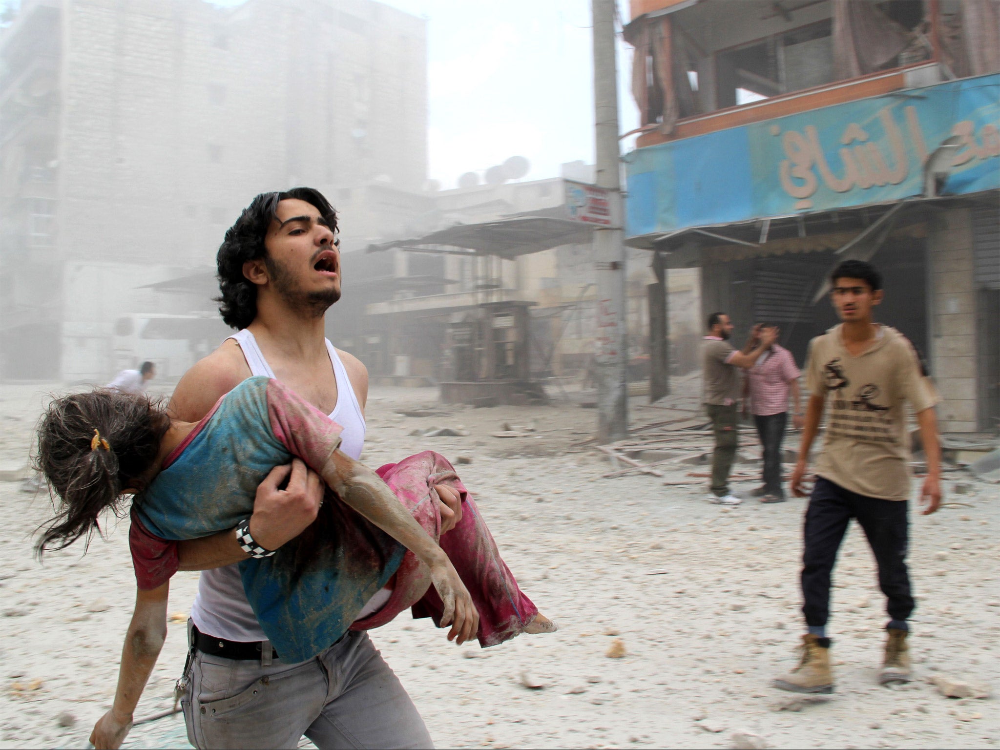 A man carrying a girl injured in a reported barrel-bomb attack by government forces in the northern city of Aleppo, on Tuesday