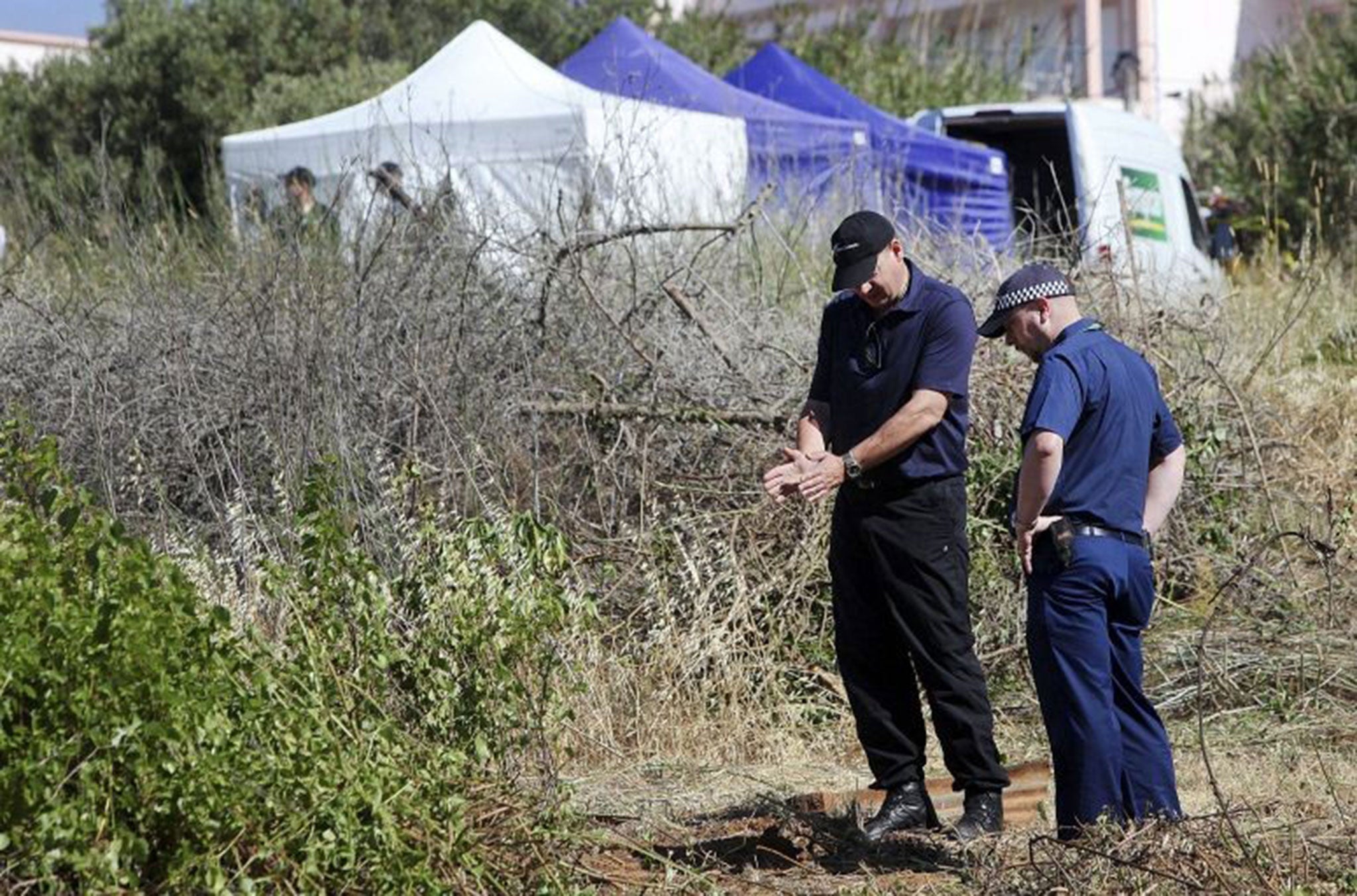 British police search scrubland next to a newly-erected tent in the search for Madeleine McCann