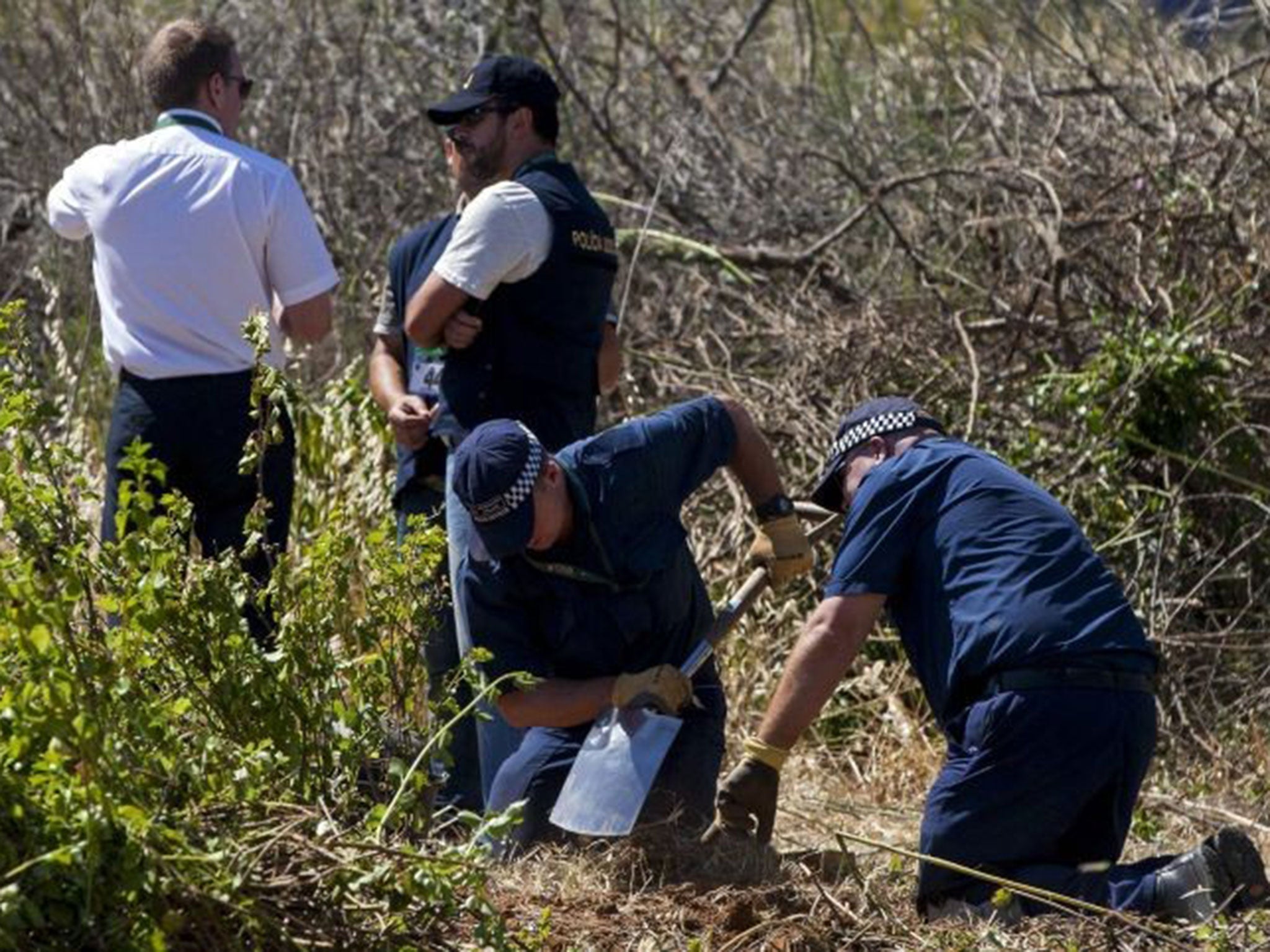 Scotland Yard detectives dig at an area of scrubland in Praia da Luz