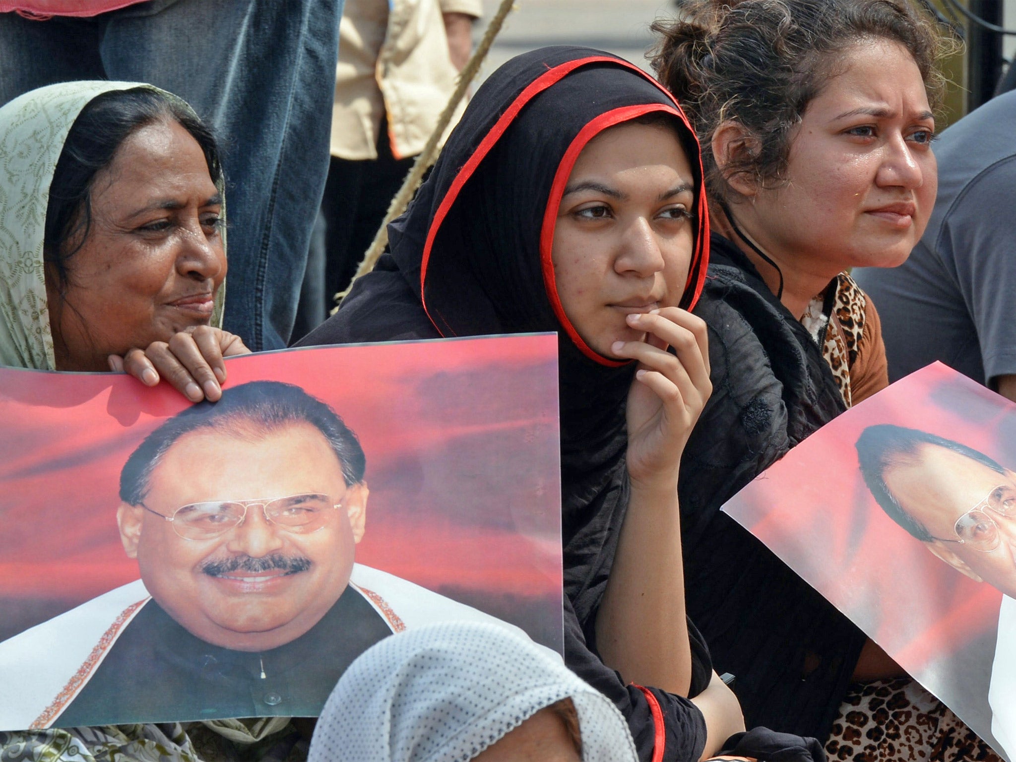 Supporters of Pakistan's Muttahida Qaumi Movement (MQM) party hold photographs of leader Altaf Hussain during a sit-in protest in Karachi